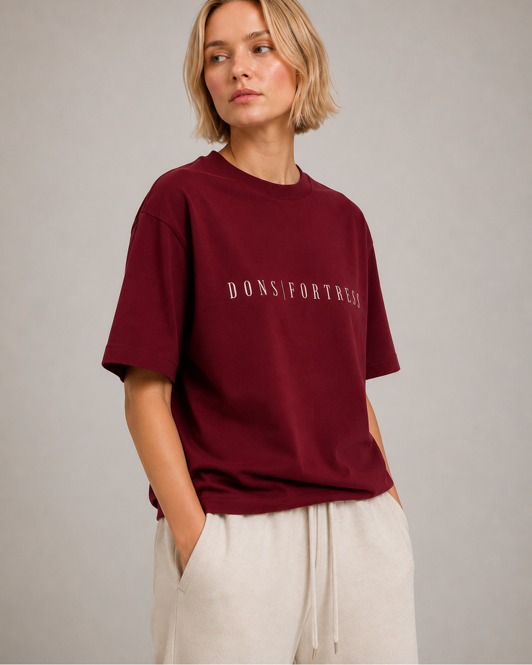 Person wearing a burgundy t-shirt with text on a plain background