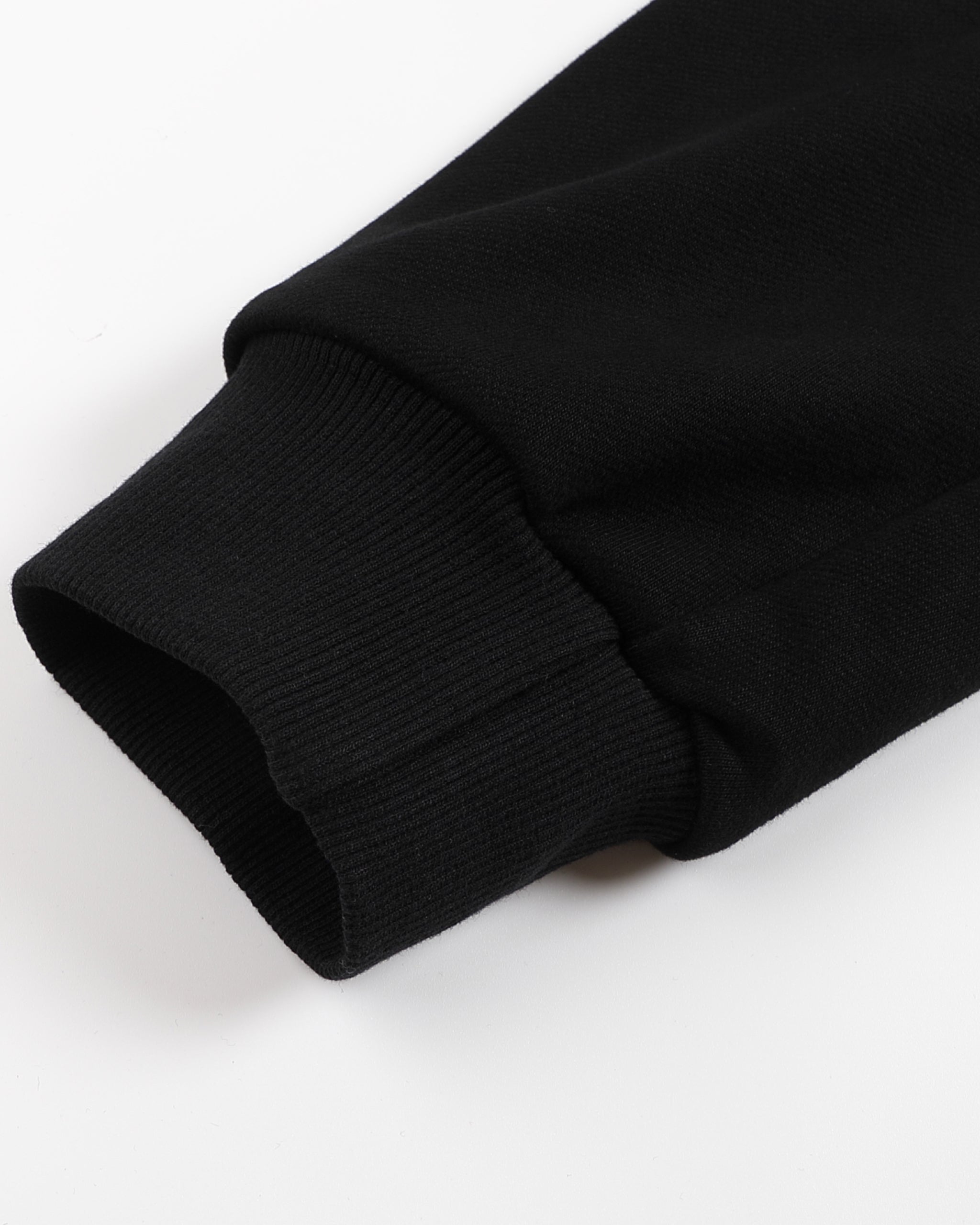 Close-up of a black sweater sleeve on a white background