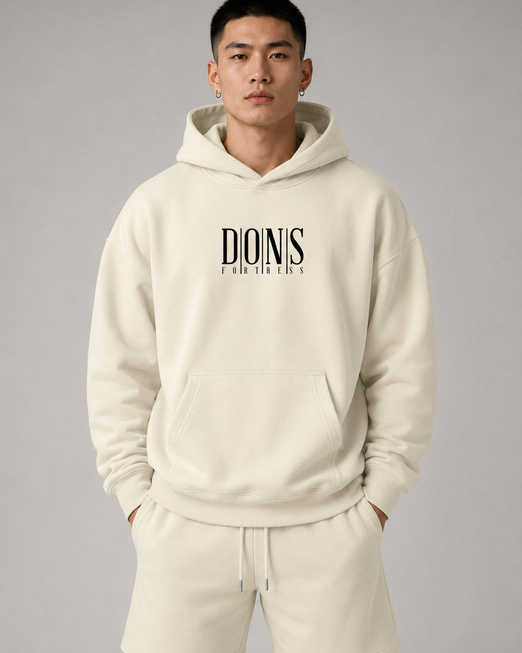 Person wearing a beige hoodie with 'Dionis' branding on a gray background