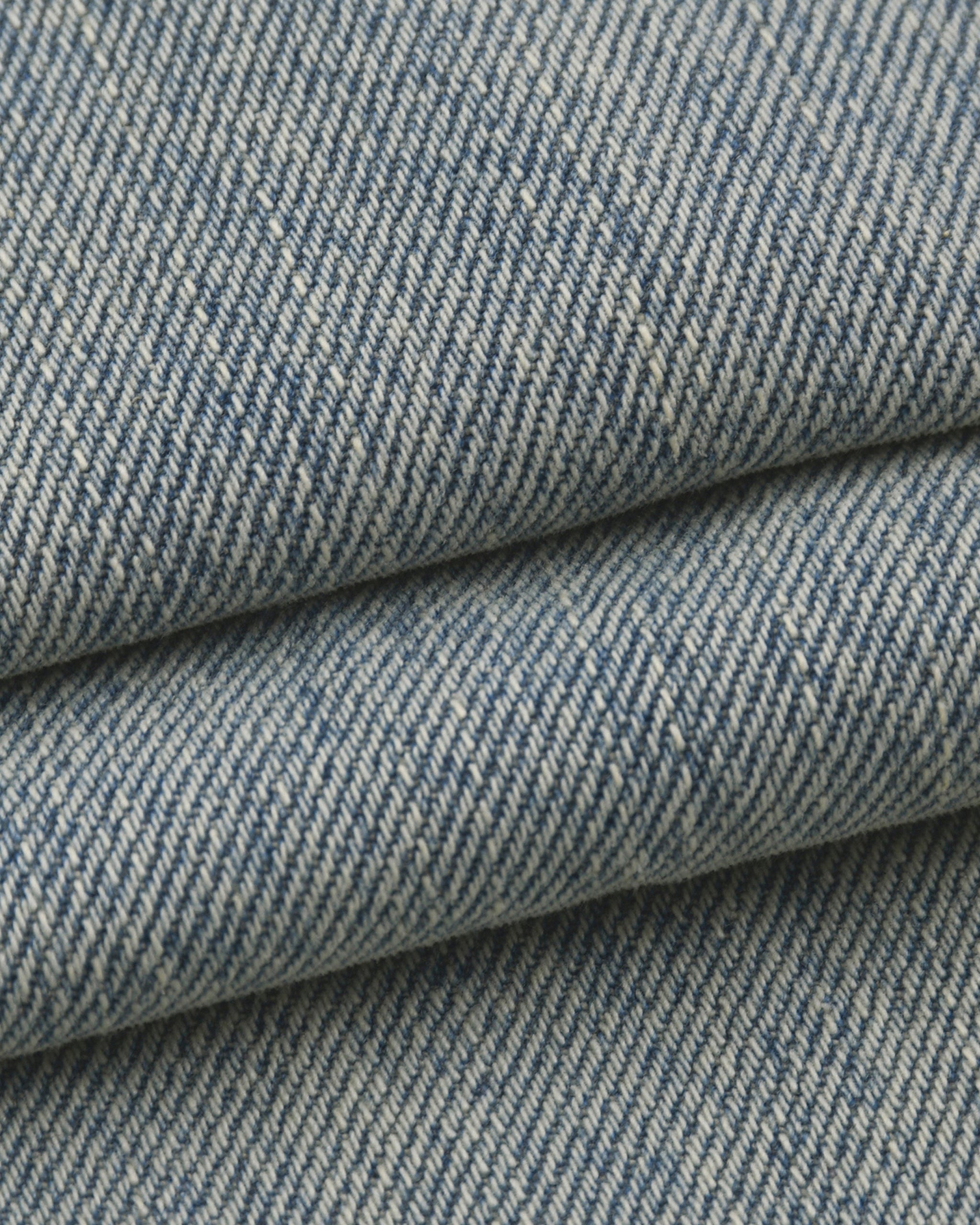 Close-up of blue denim fabric with a subtle pattern