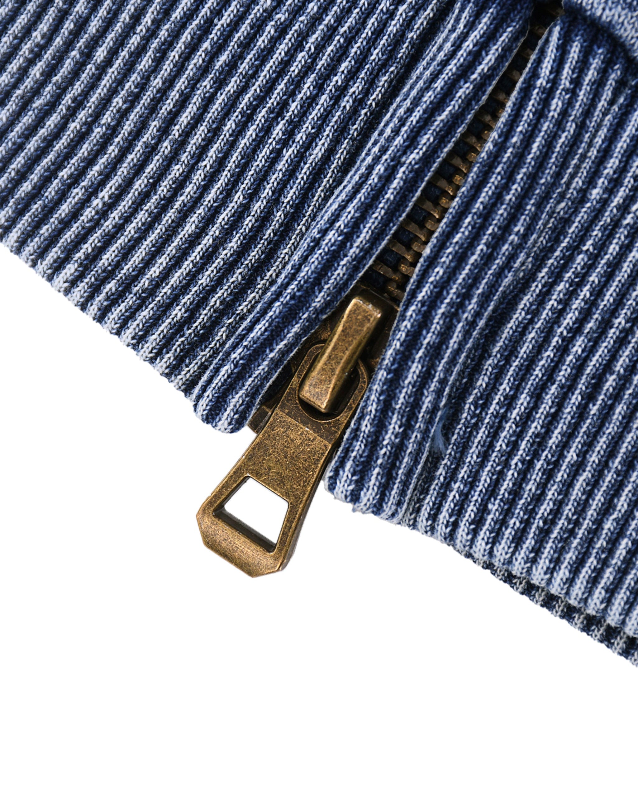 Close-up of a blue ribbed fabric with a brass zipper pull on a white background