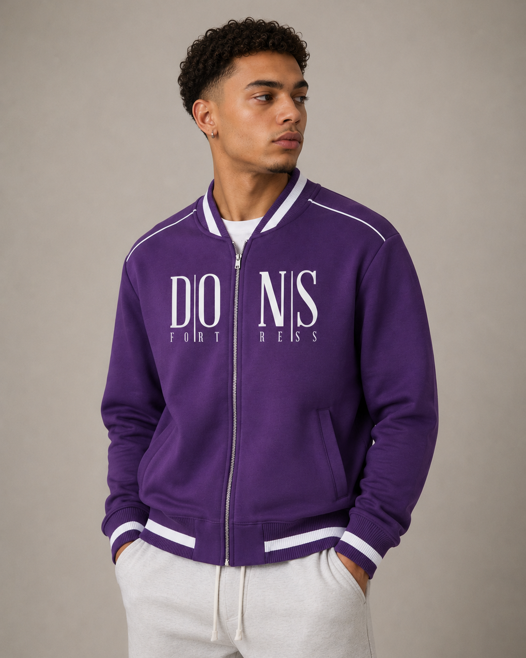 Person wearing a purple varsity jacket with white text on a neutral background