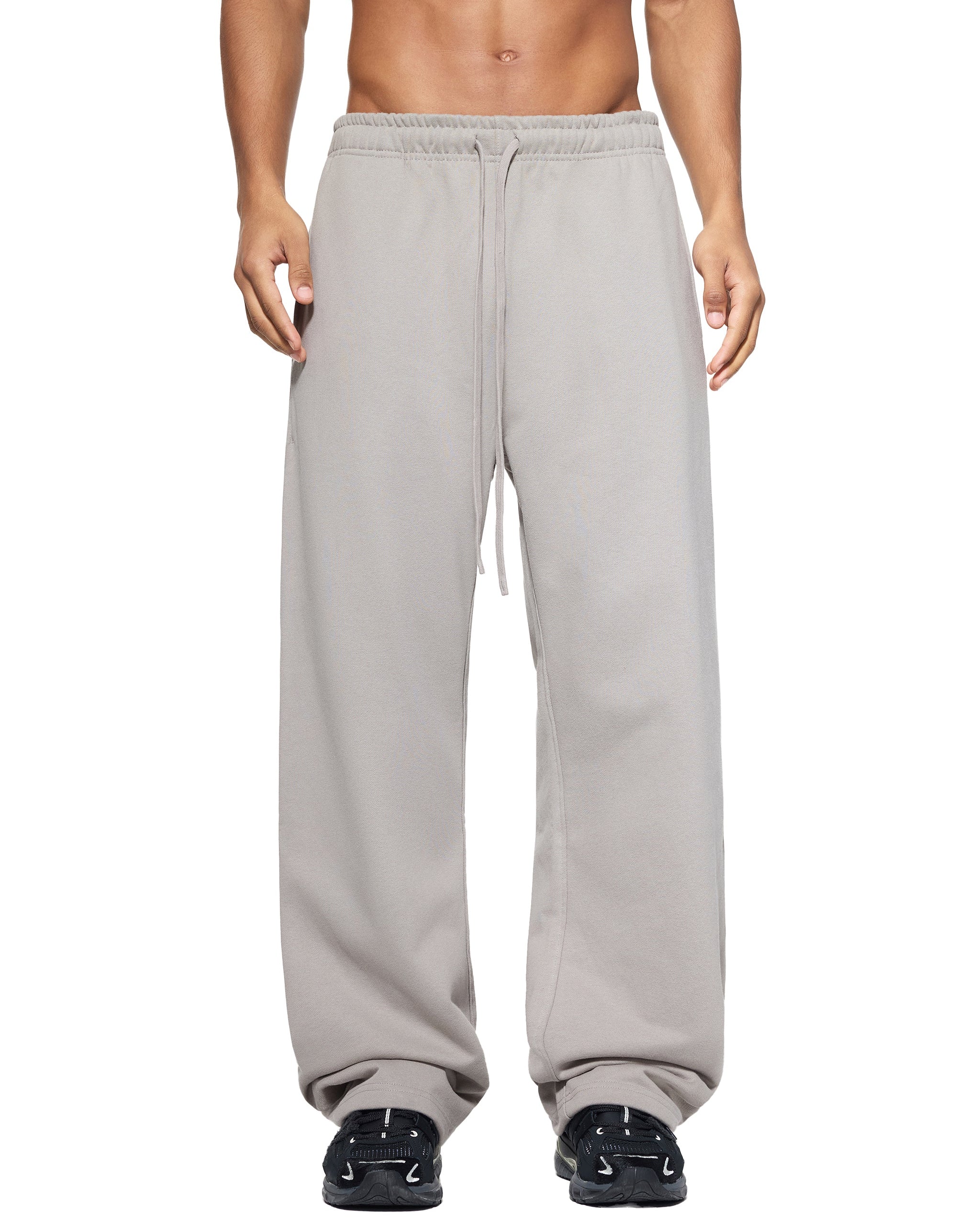 Gray sweatpants worn by a person on a white background