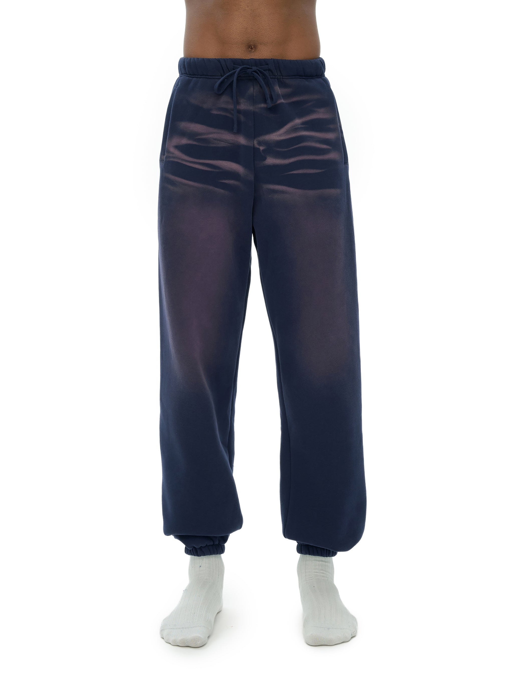 Navy blue jogger pants worn by a person on a white background