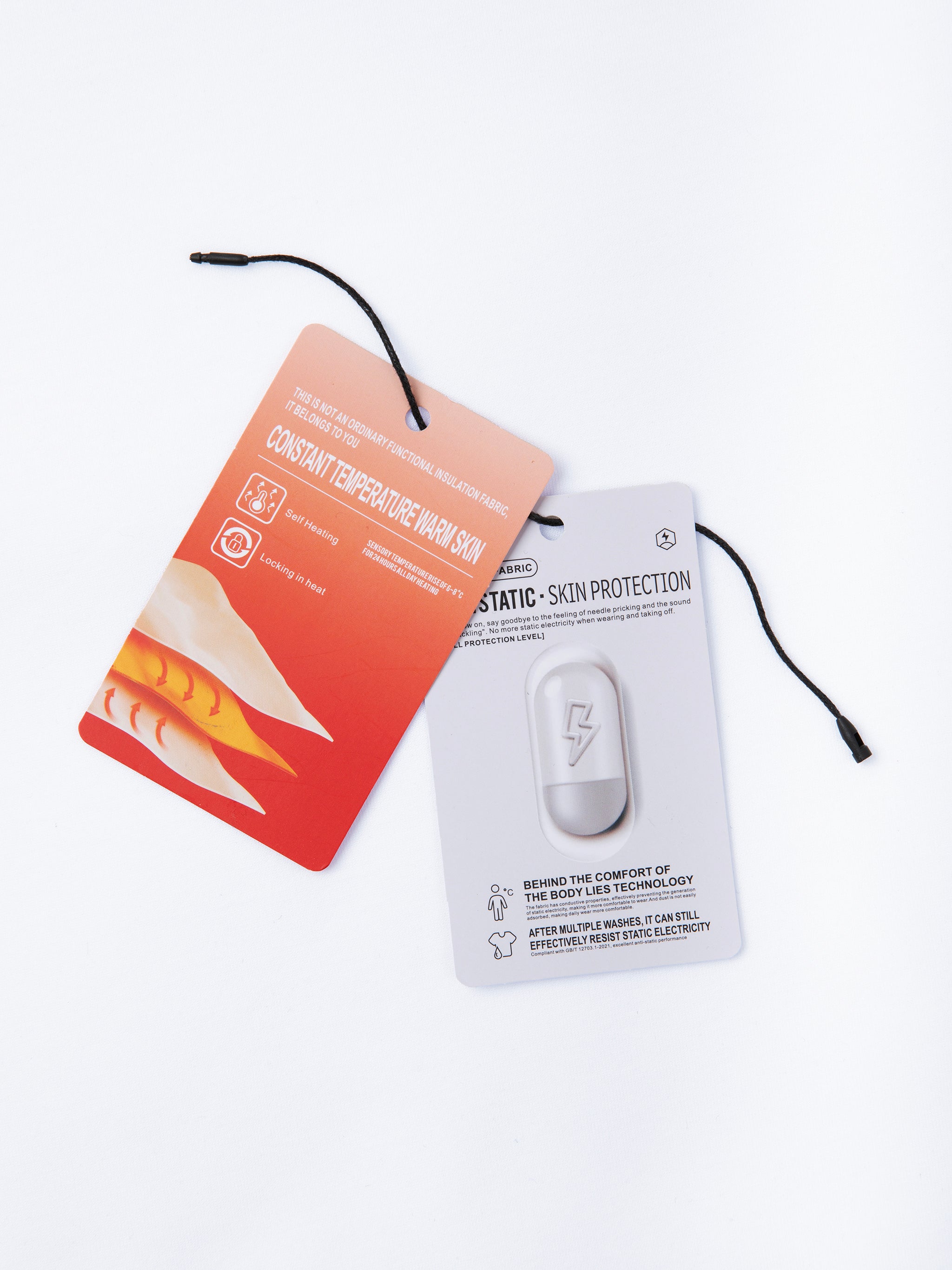 Product packaging with a white device and orange and white cards on a light gray background