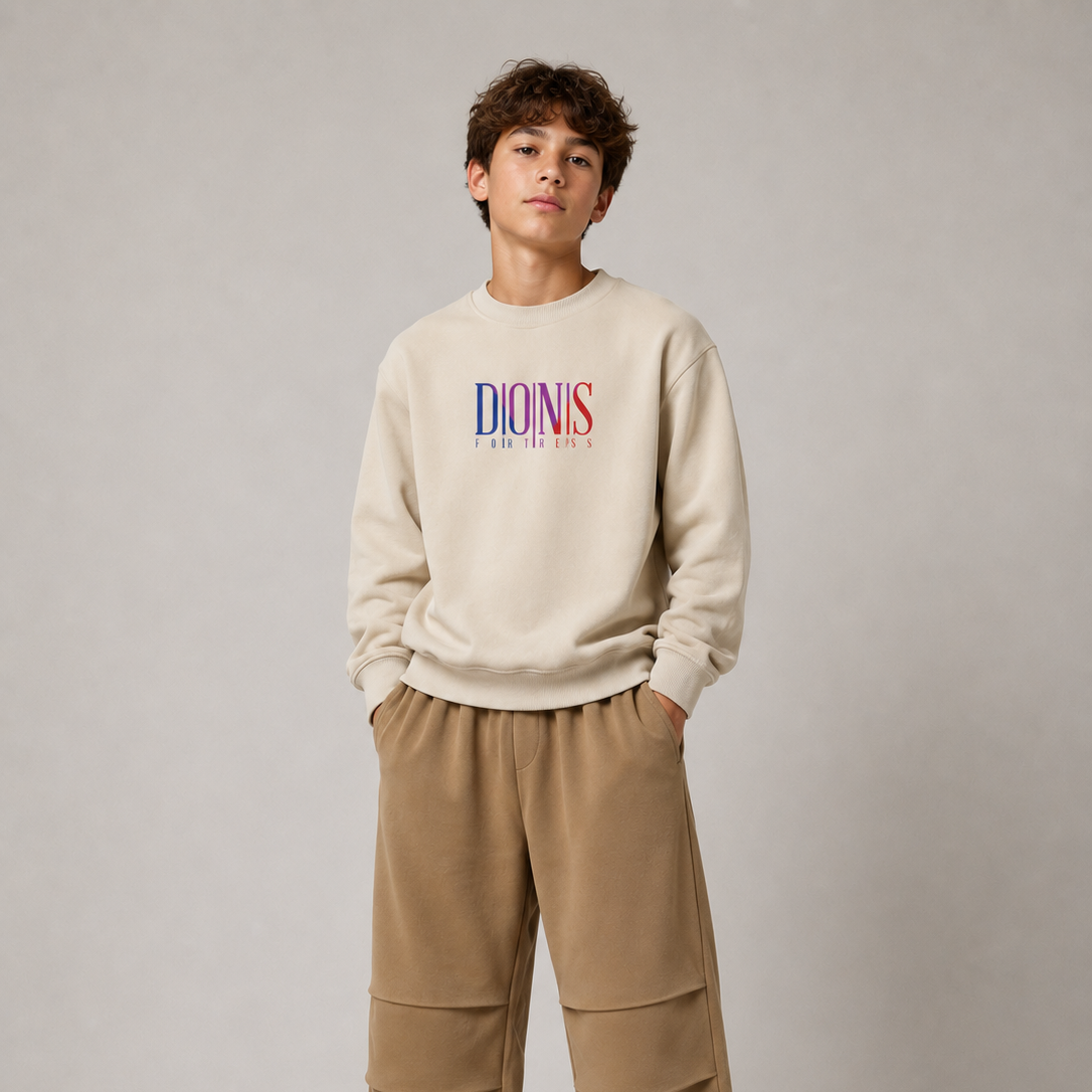 Person wearing a beige sweatshirt with colorful text and beige pants on a plain background
