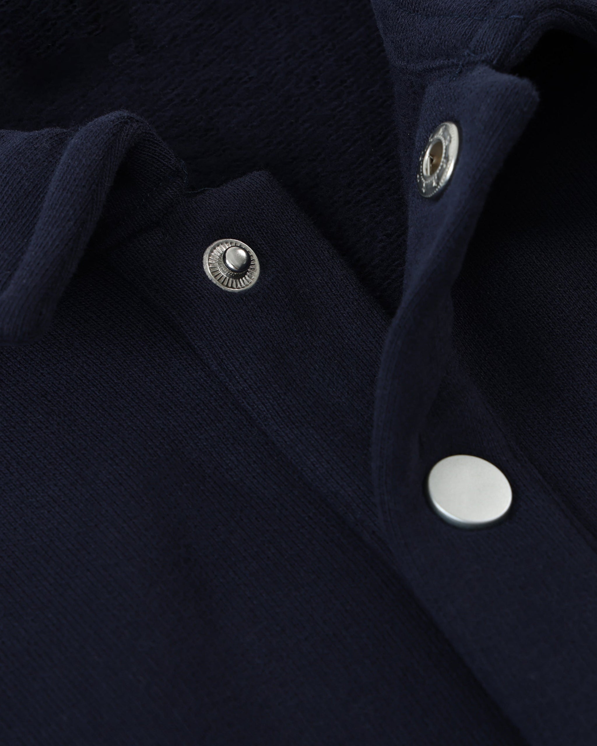 Close-up of a navy blue fabric with silver buttons