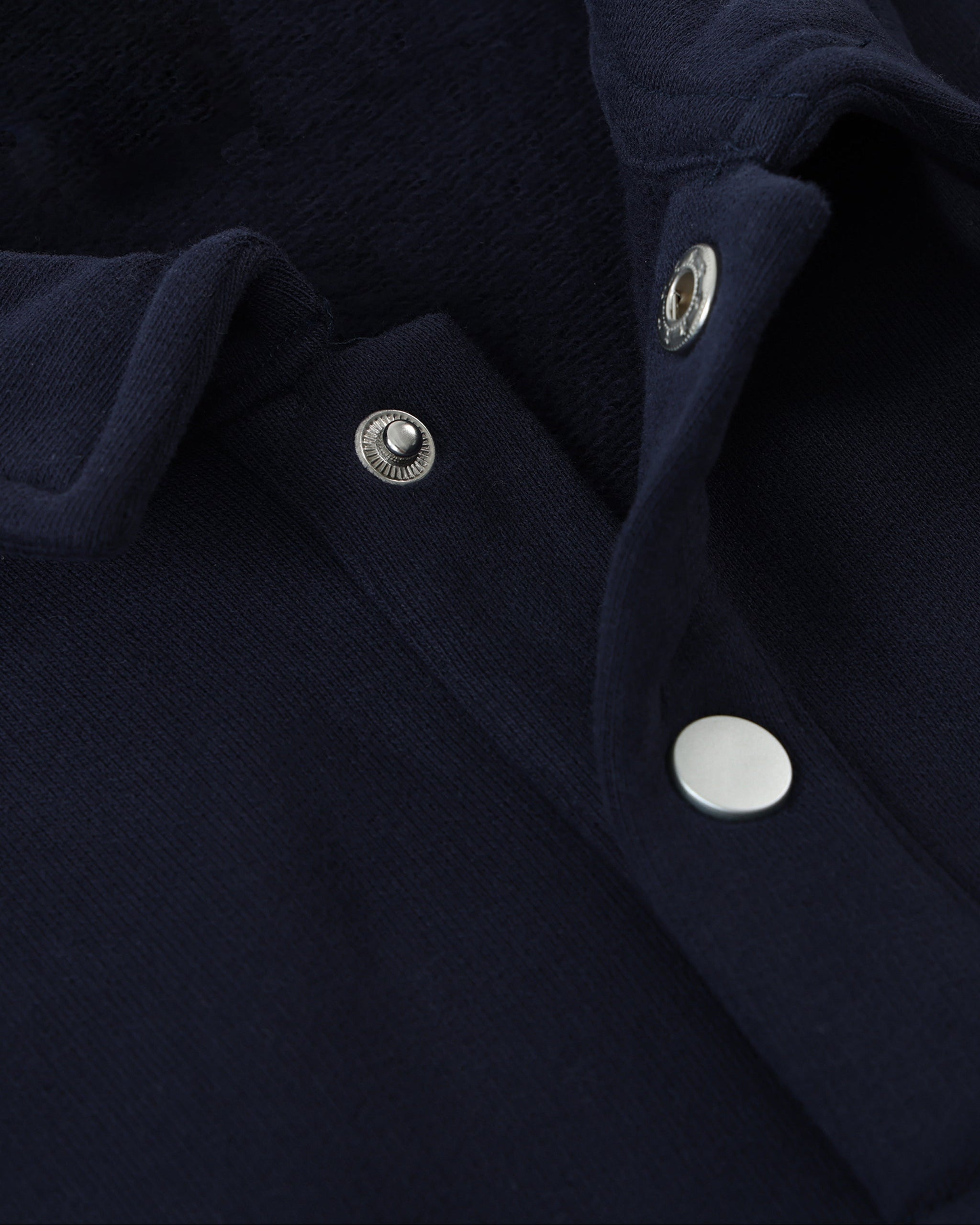 Close-up of a navy blue fabric with silver buttons