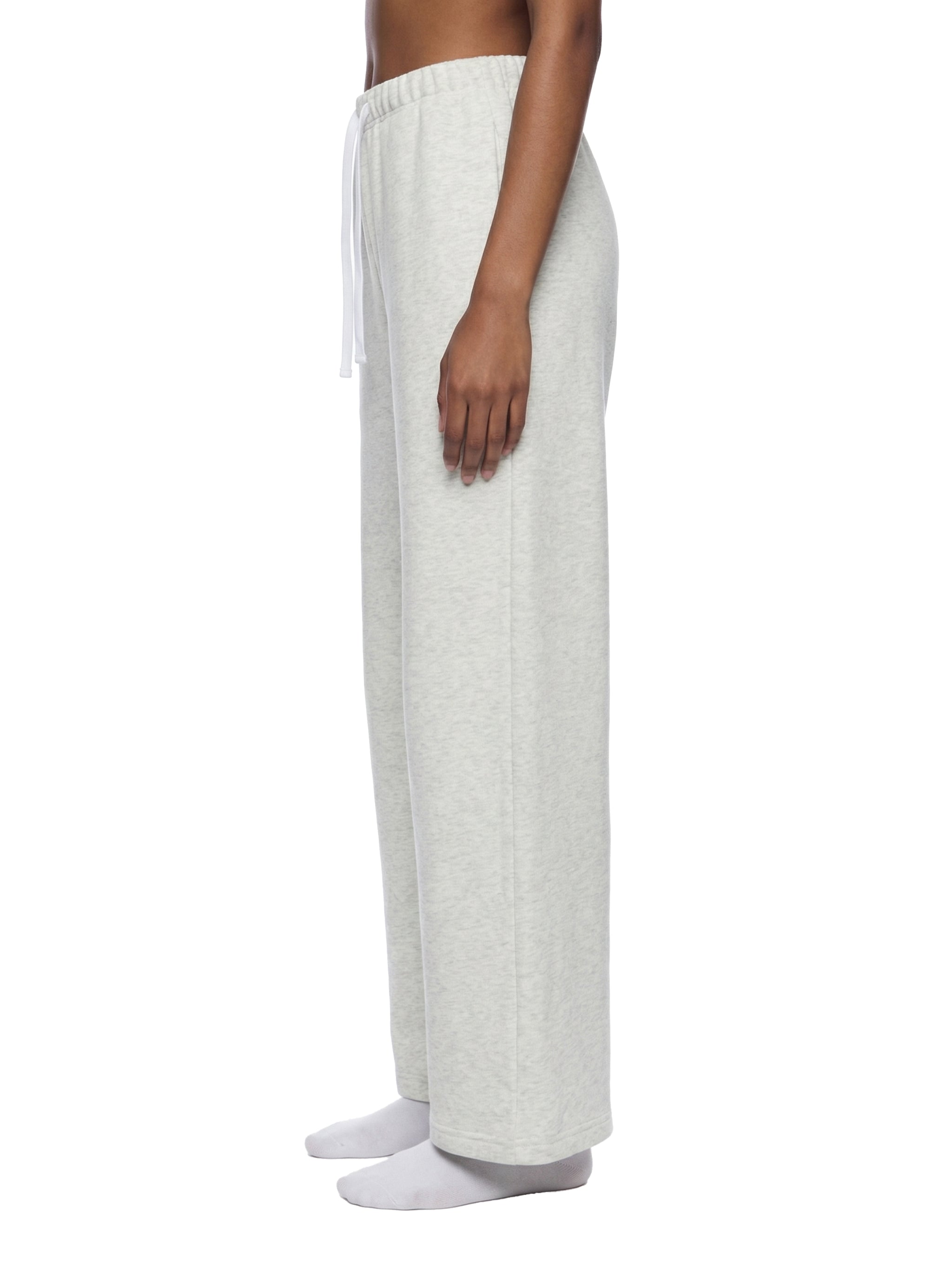 Person wearing white lounge pants on a white background
