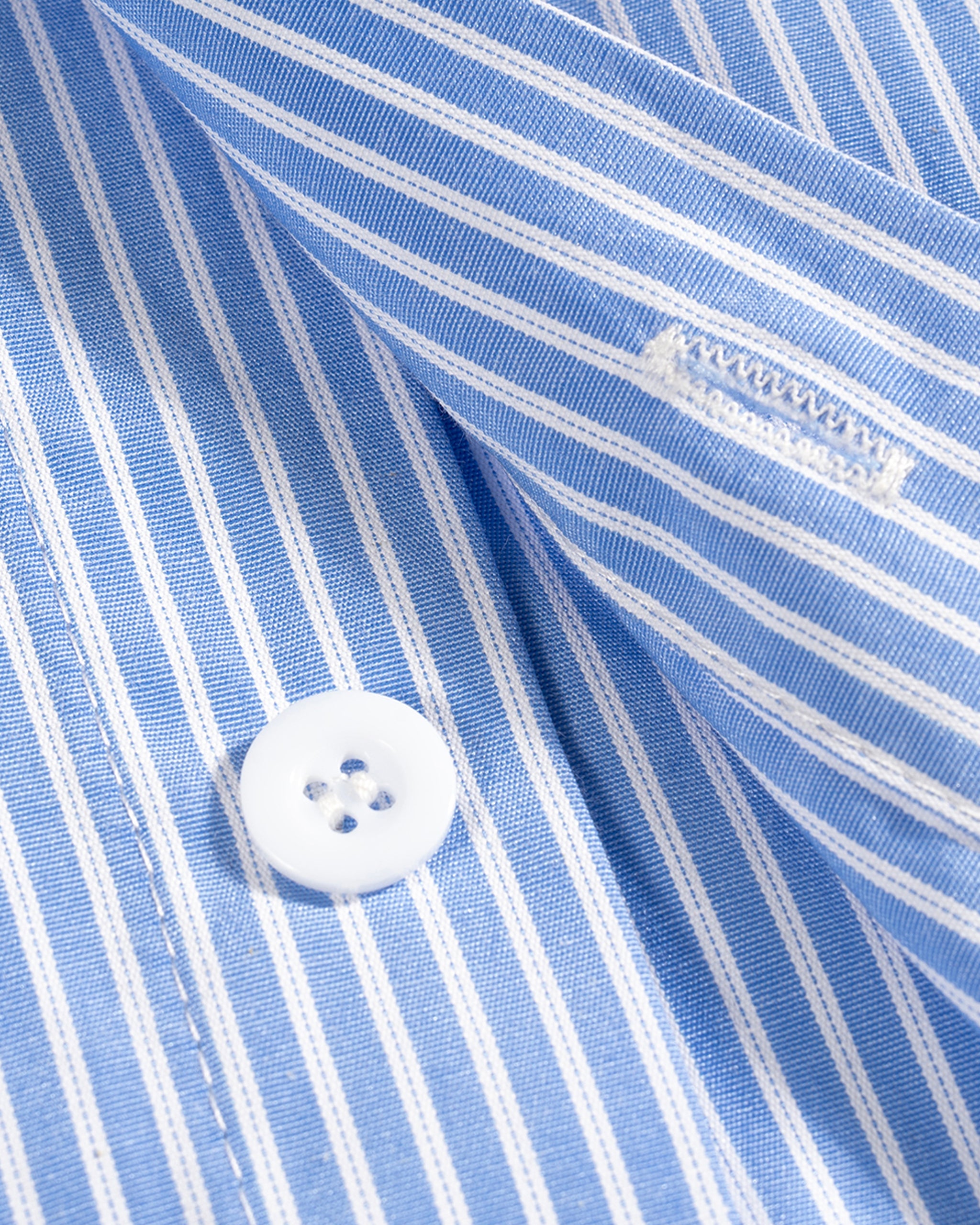 Close-up of a blue and white striped shirt with a button, showing a brand label.