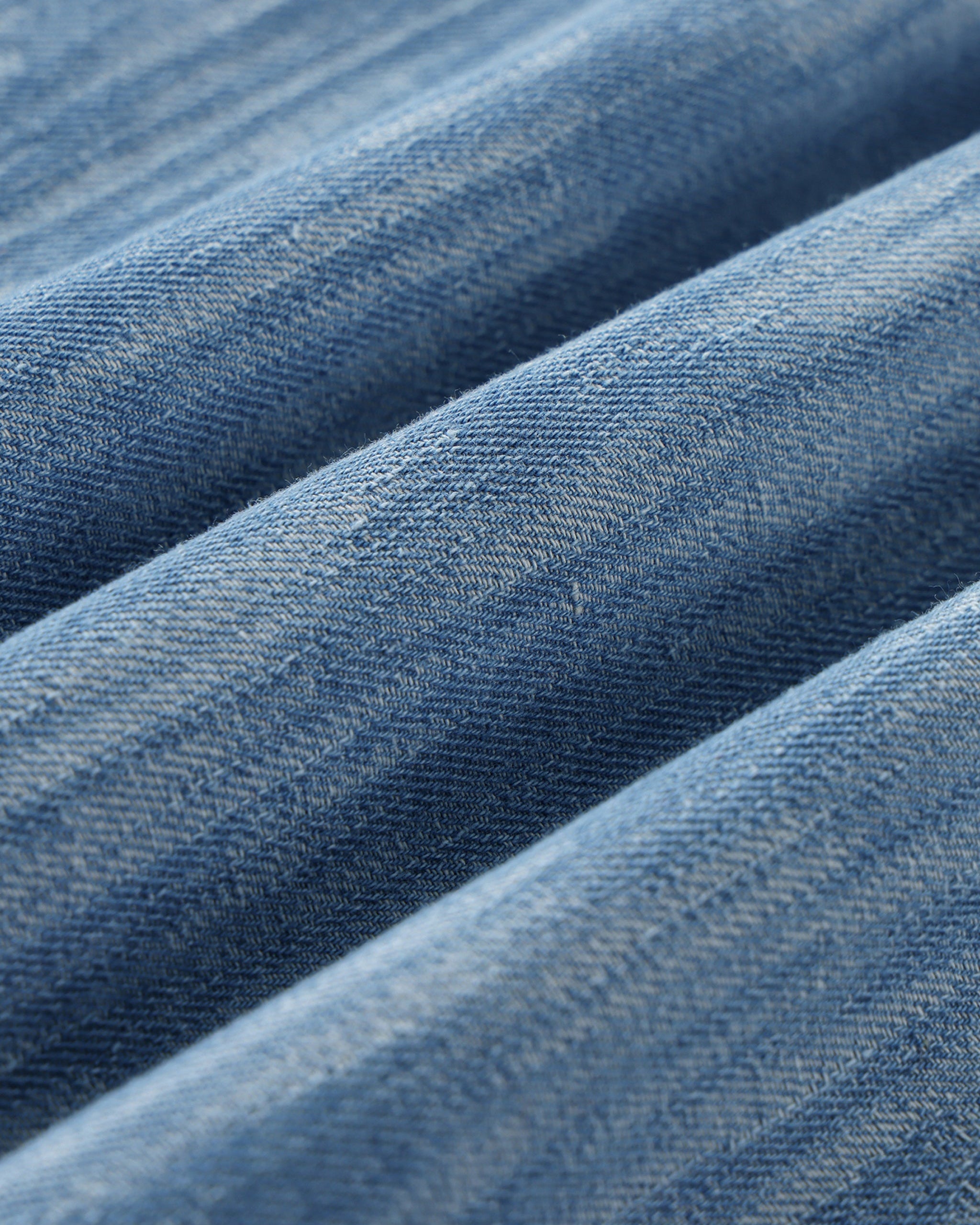 Close-up of blue denim fabric with a subtle pattern