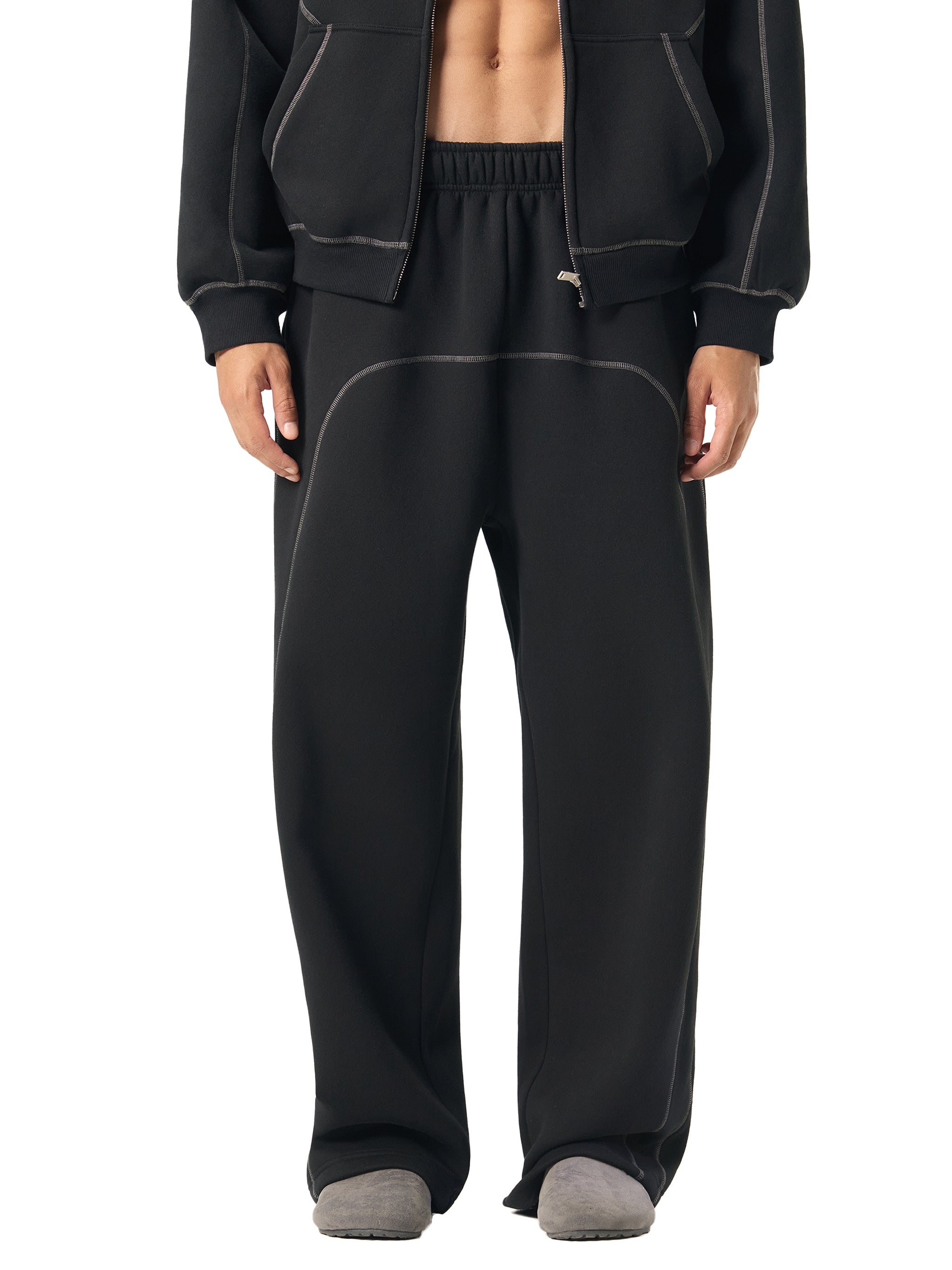 Person wearing black tracksuit on a white background