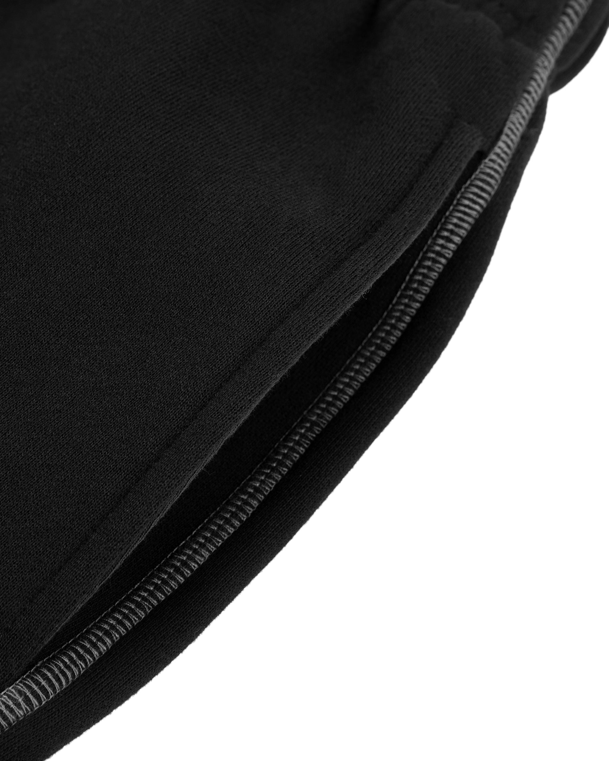 Close-up of black pants with a zip on a white background