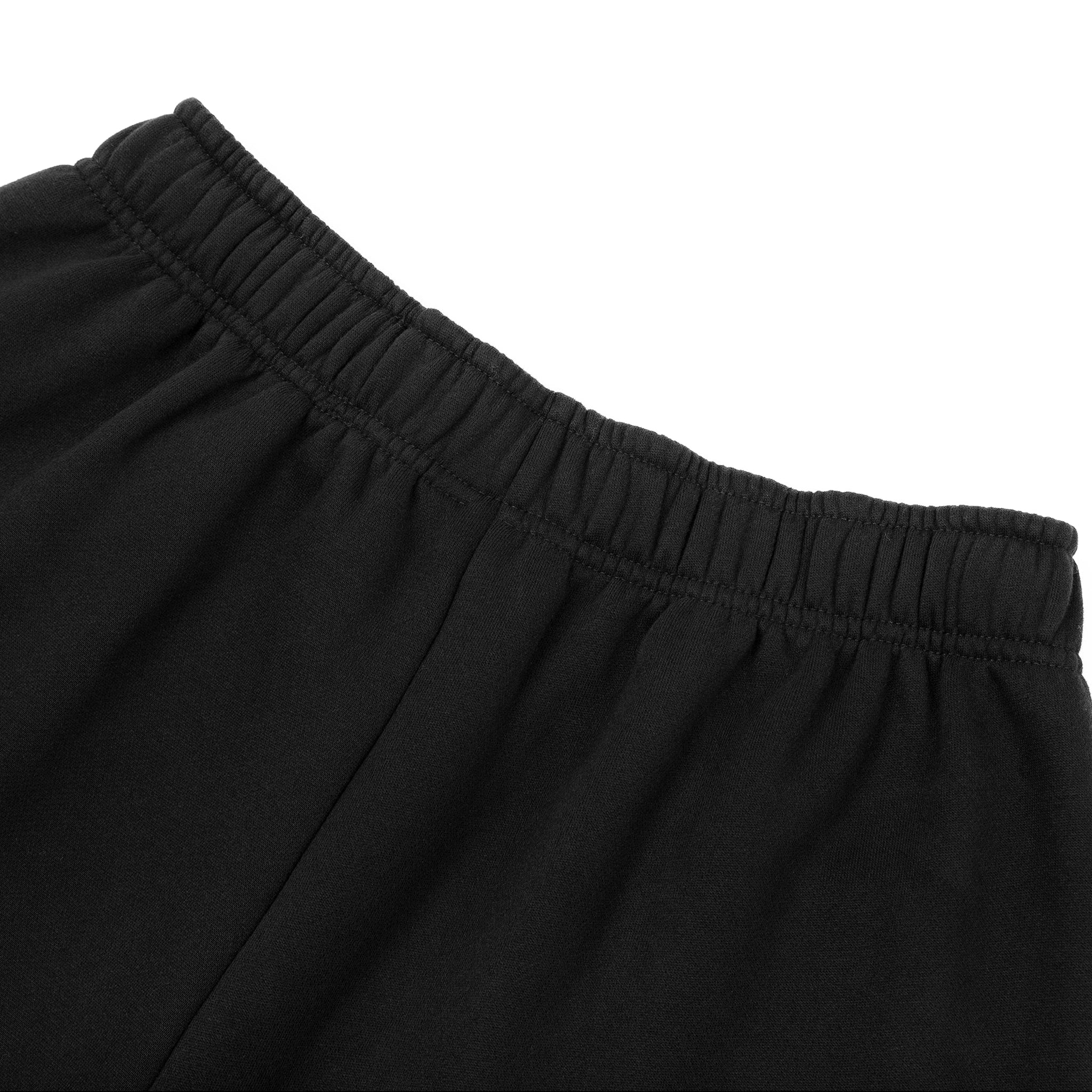 Close-up of black pants with an elastic waistband on a white background