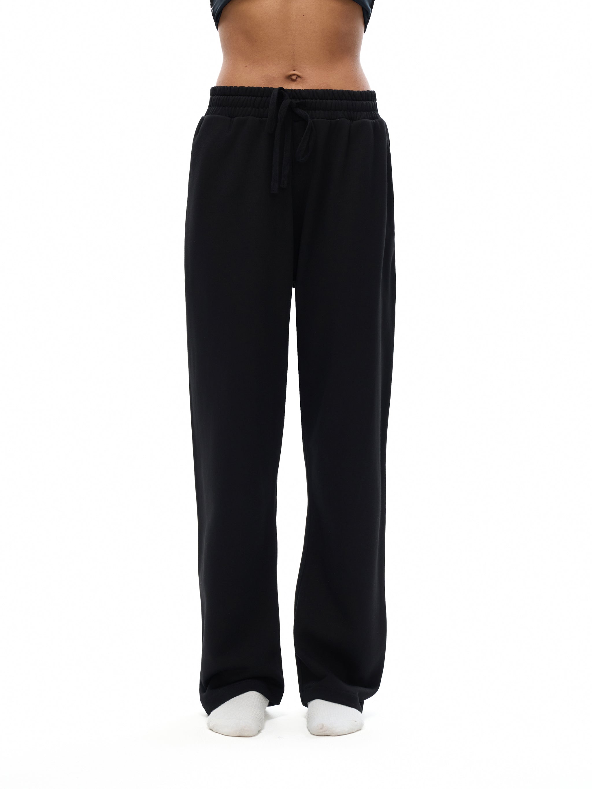 Black sweatpants worn by a person on a white background