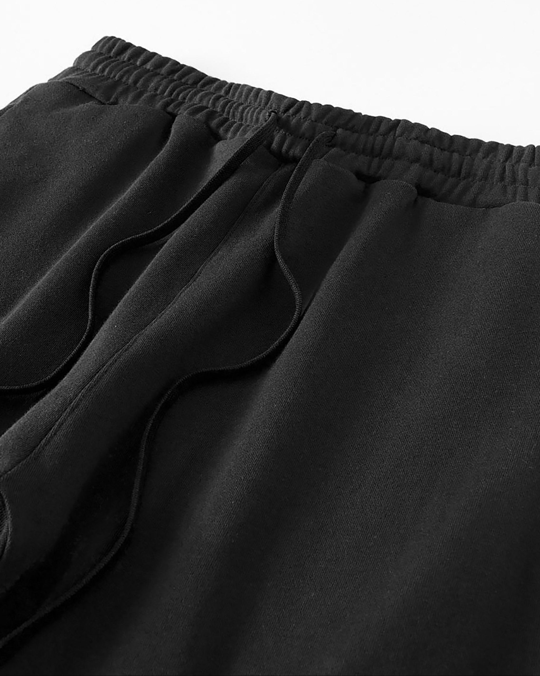 Close-up of black pants with an elastic waistband on a white background