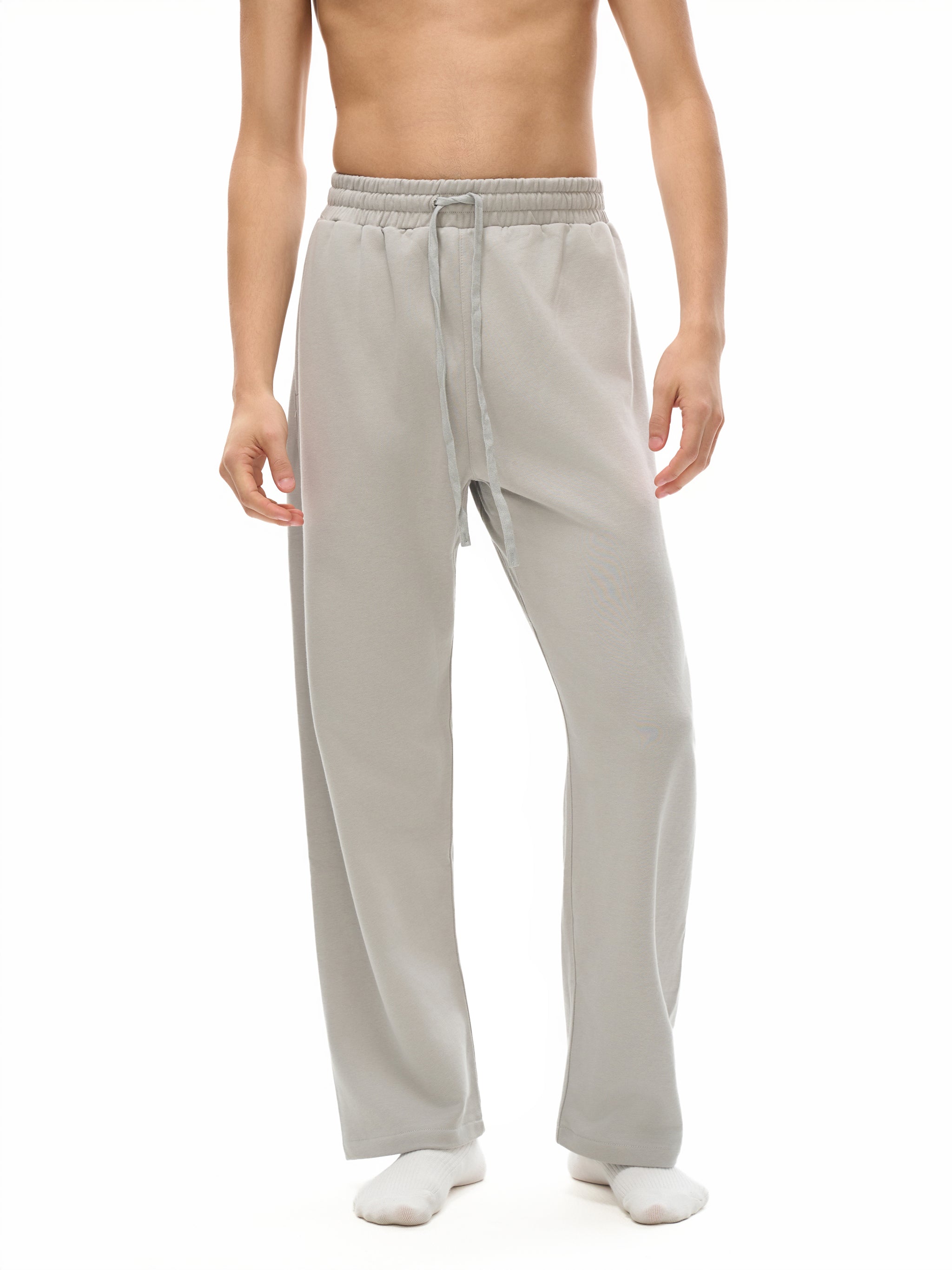 Person wearing light gray pants on a white background