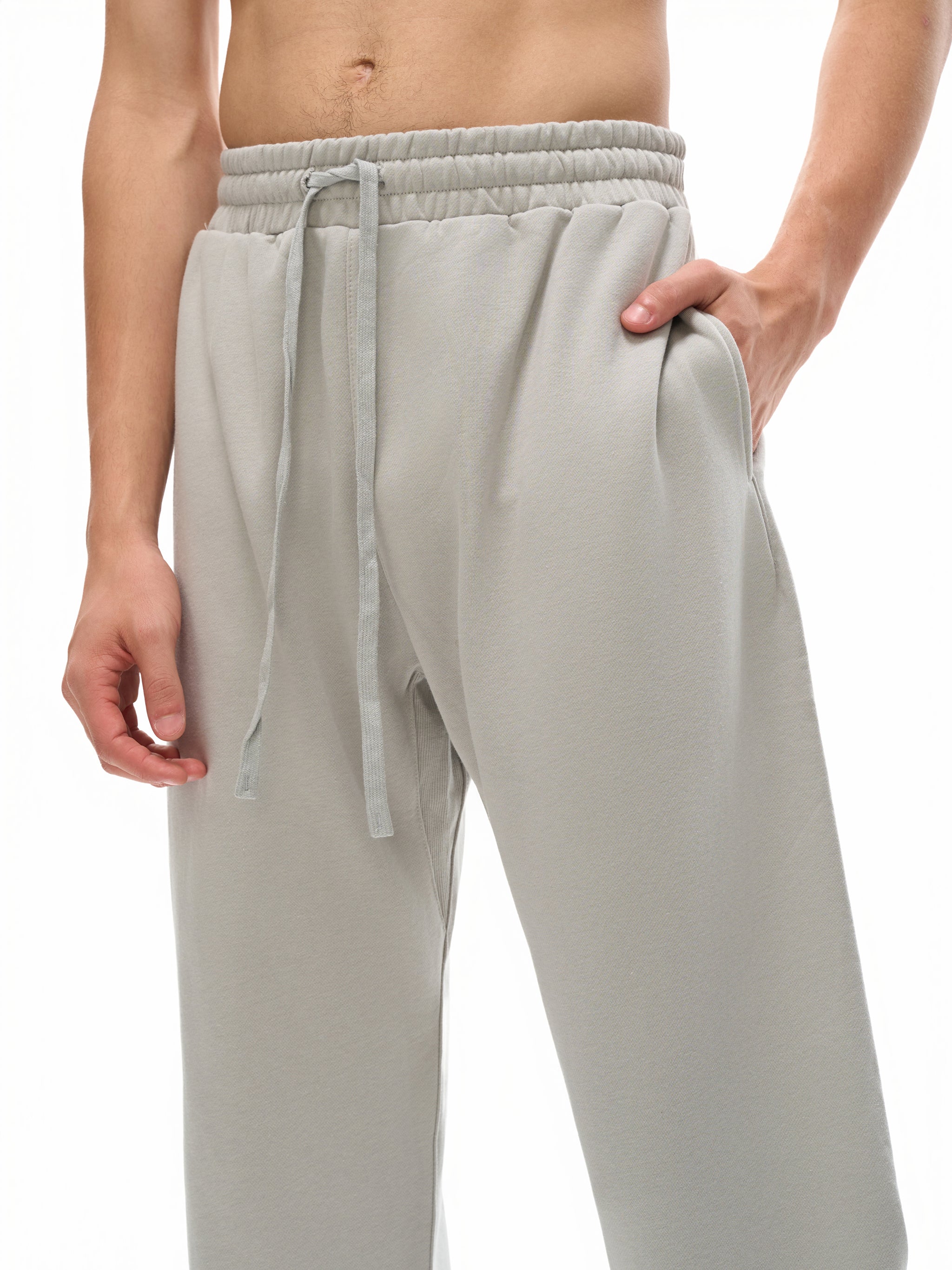 Light gray sweatpants worn by a person on a white background