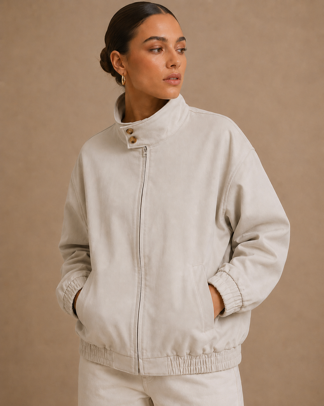Woman wearing a beige jacket against a beige background