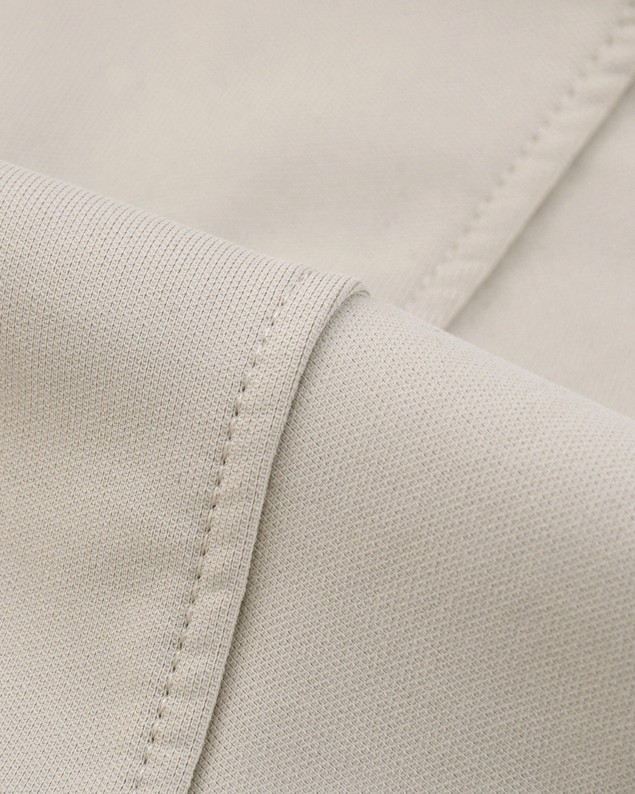 Close-up of beige fabric with stitching detail
