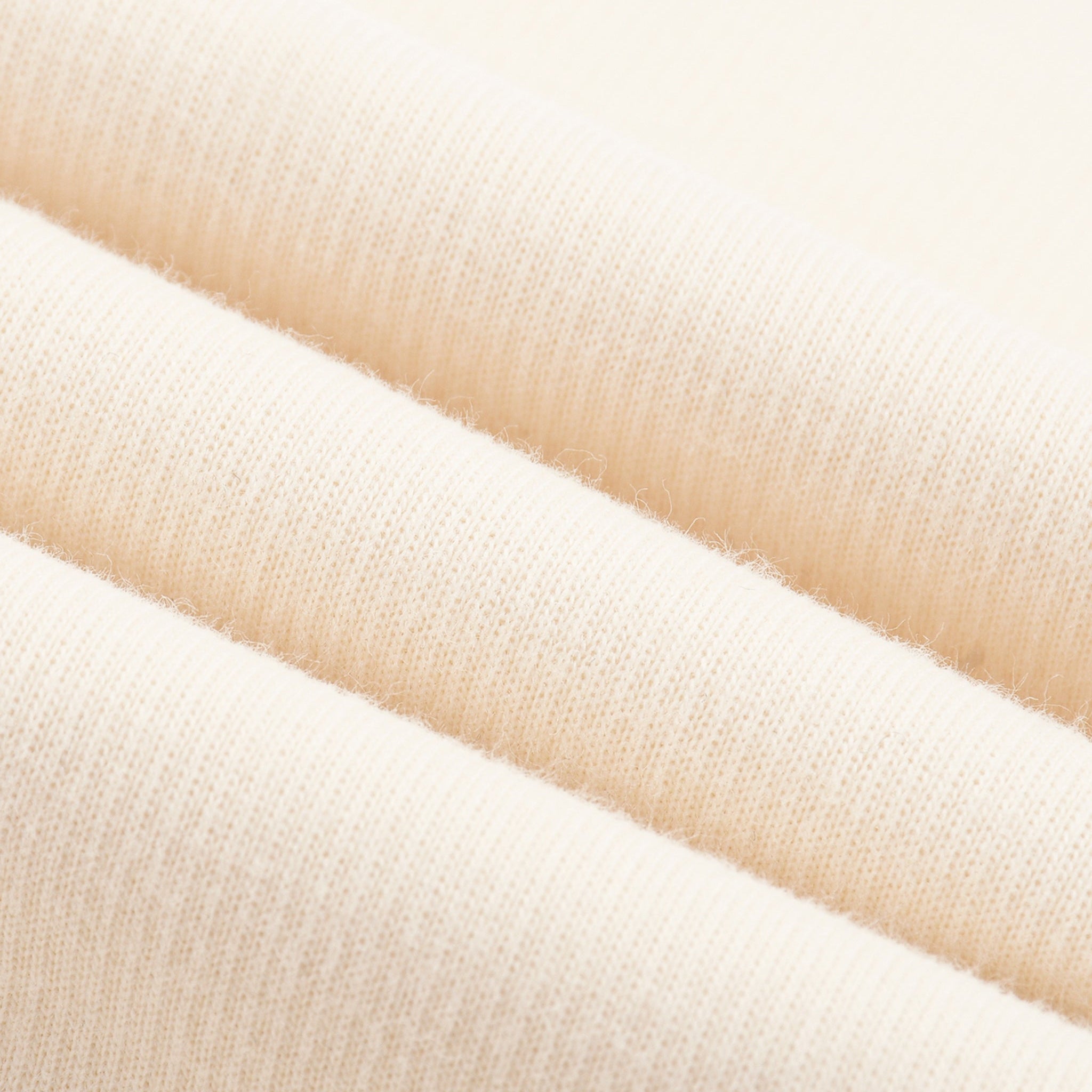Close-up of beige fabric swatches stacked on top of each other.