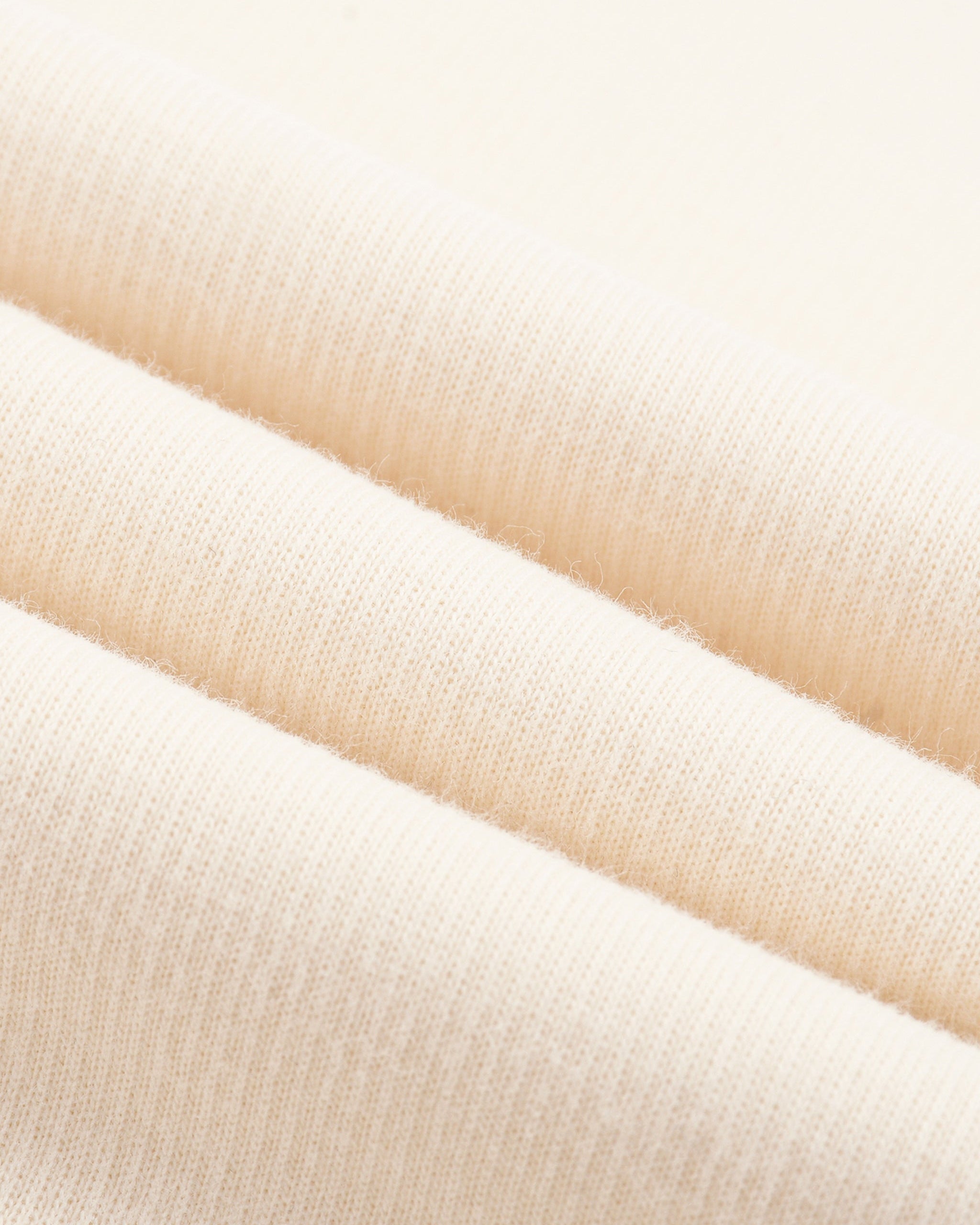 Close-up of beige fabric swatches stacked on top of each other.