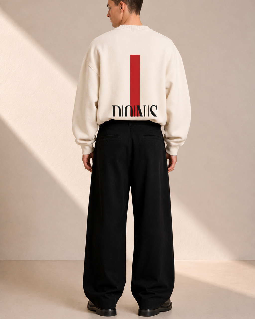 Person wearing a white sweatshirt with a logo on the back, standing against a plain background