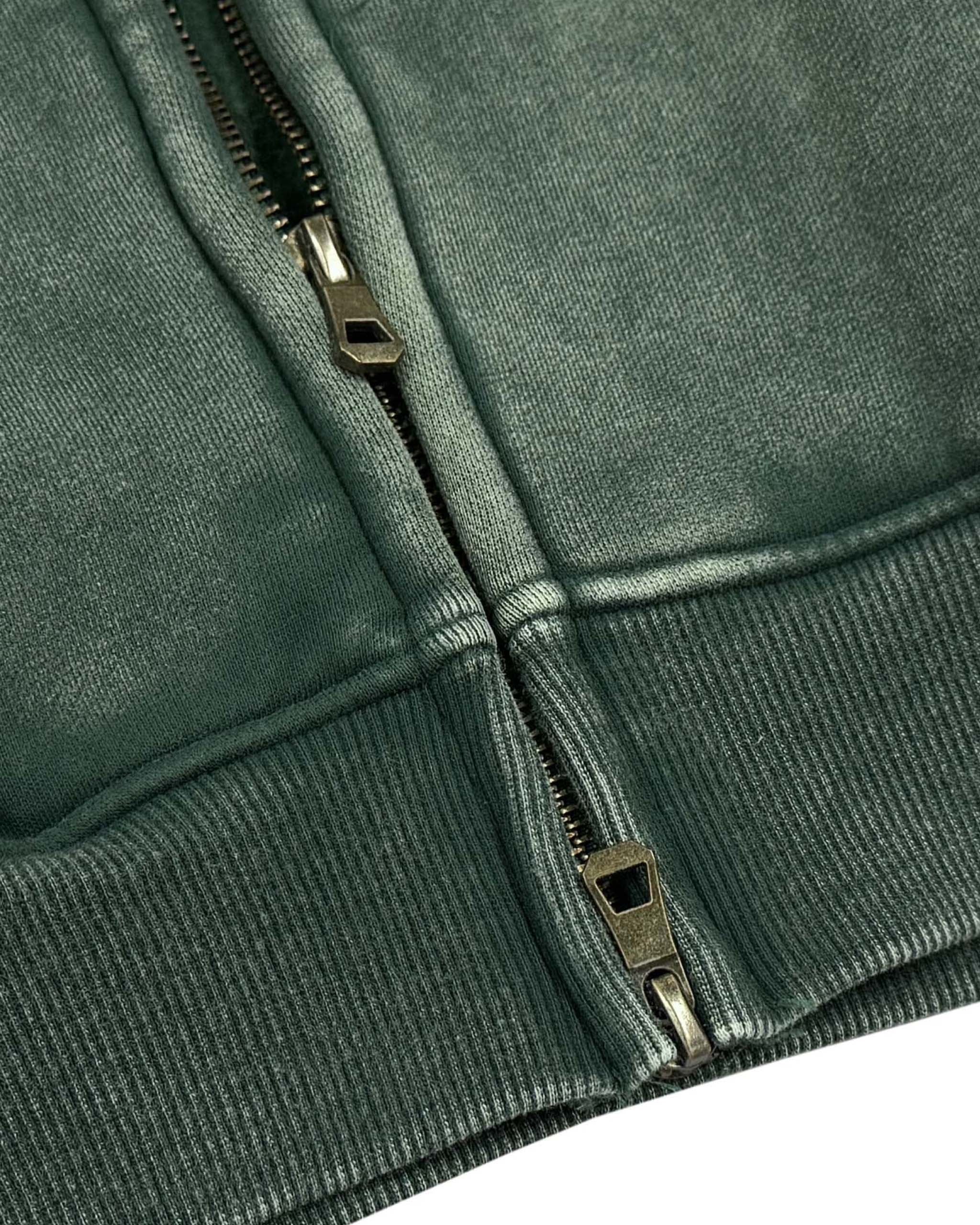 Close-up of a green jacket zipper on a white background