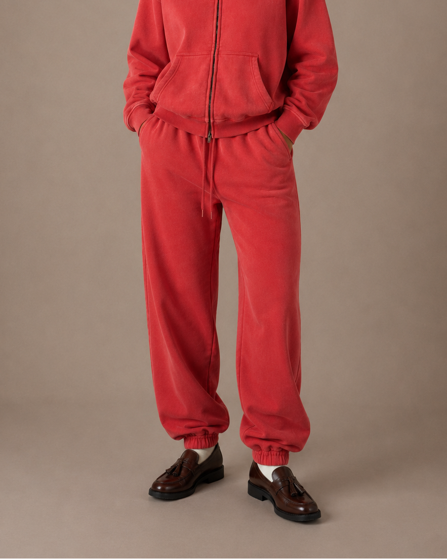 Person wearing a red tracksuit with a logo on a beige background