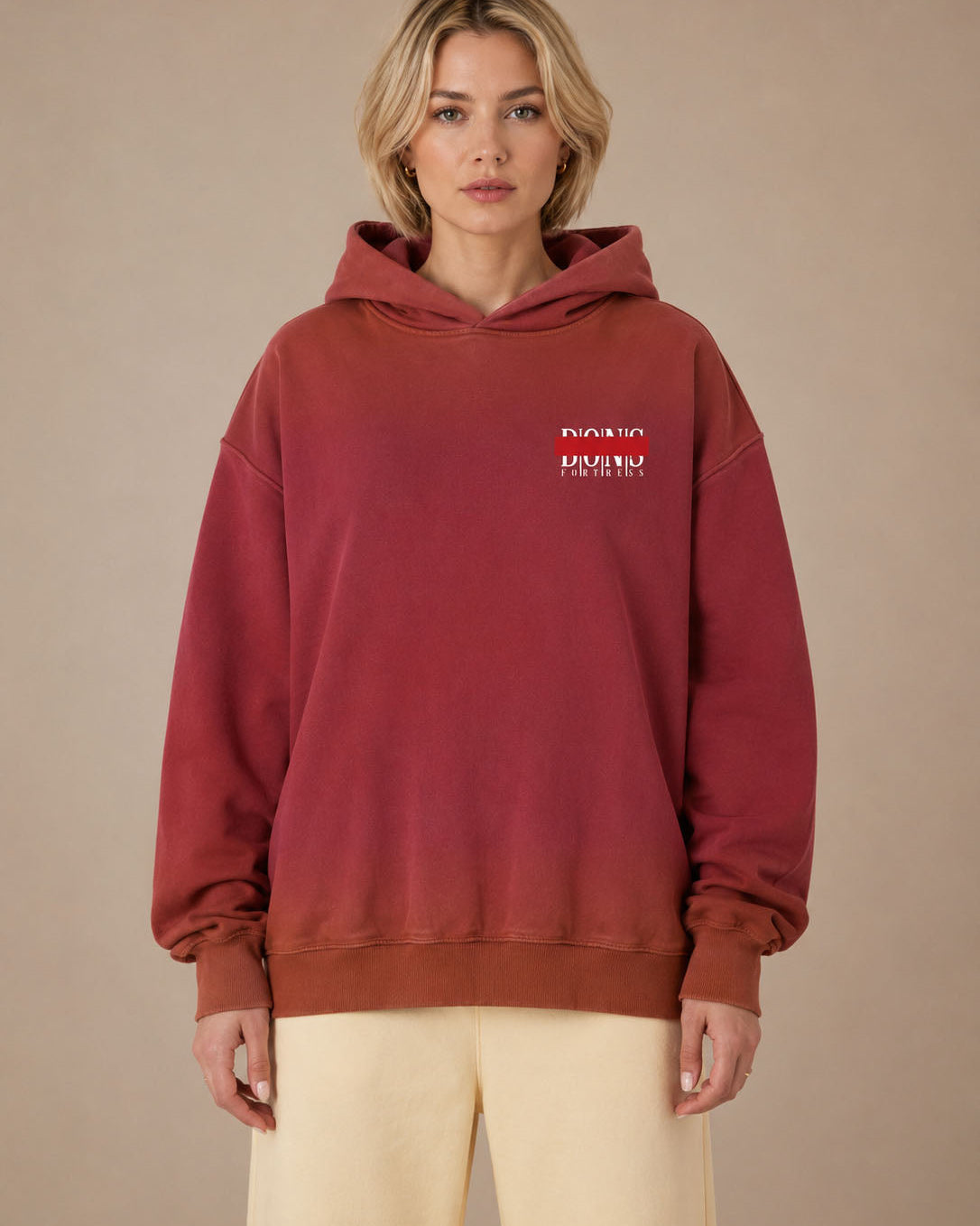 Person wearing a red hoodie with a logo on a beige background