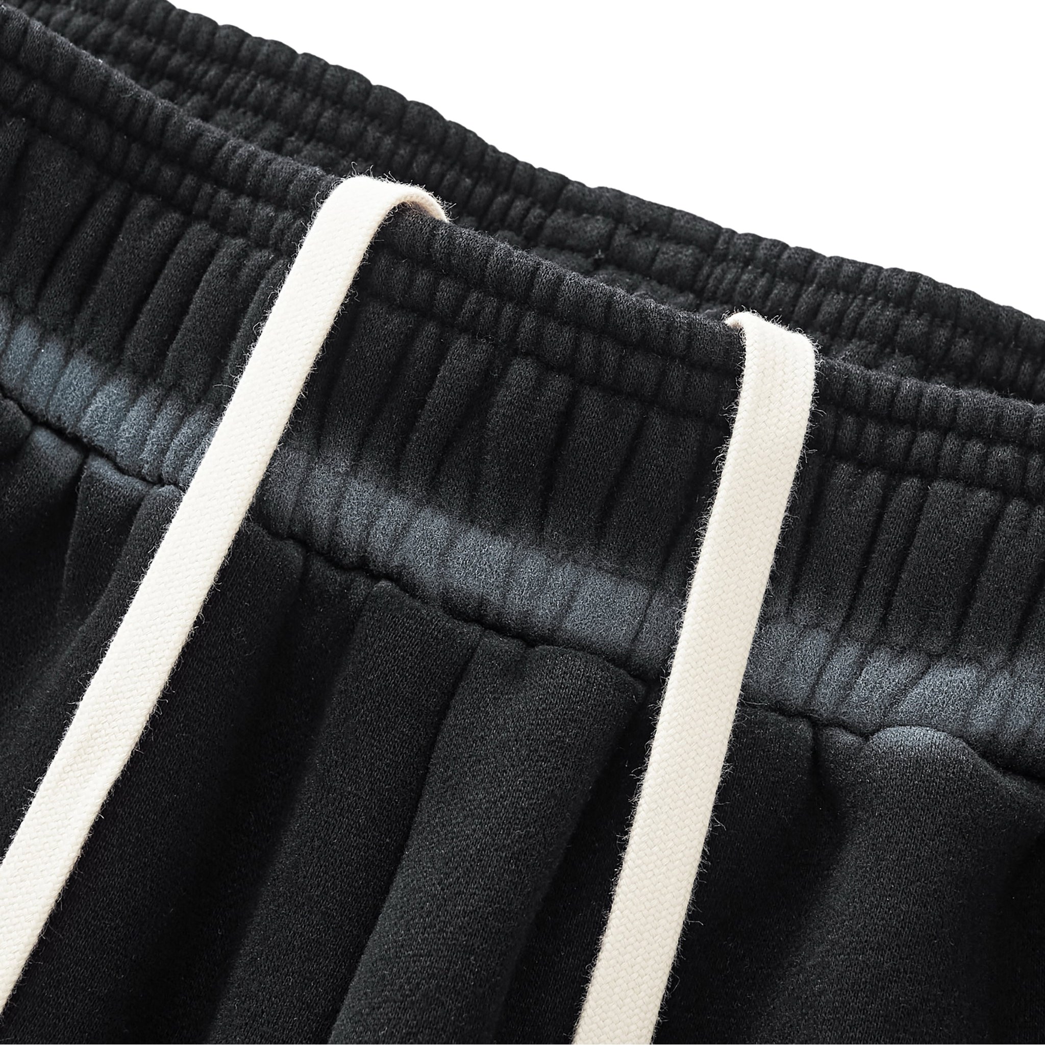 Close-up of black pants with white drawstrings on a white background