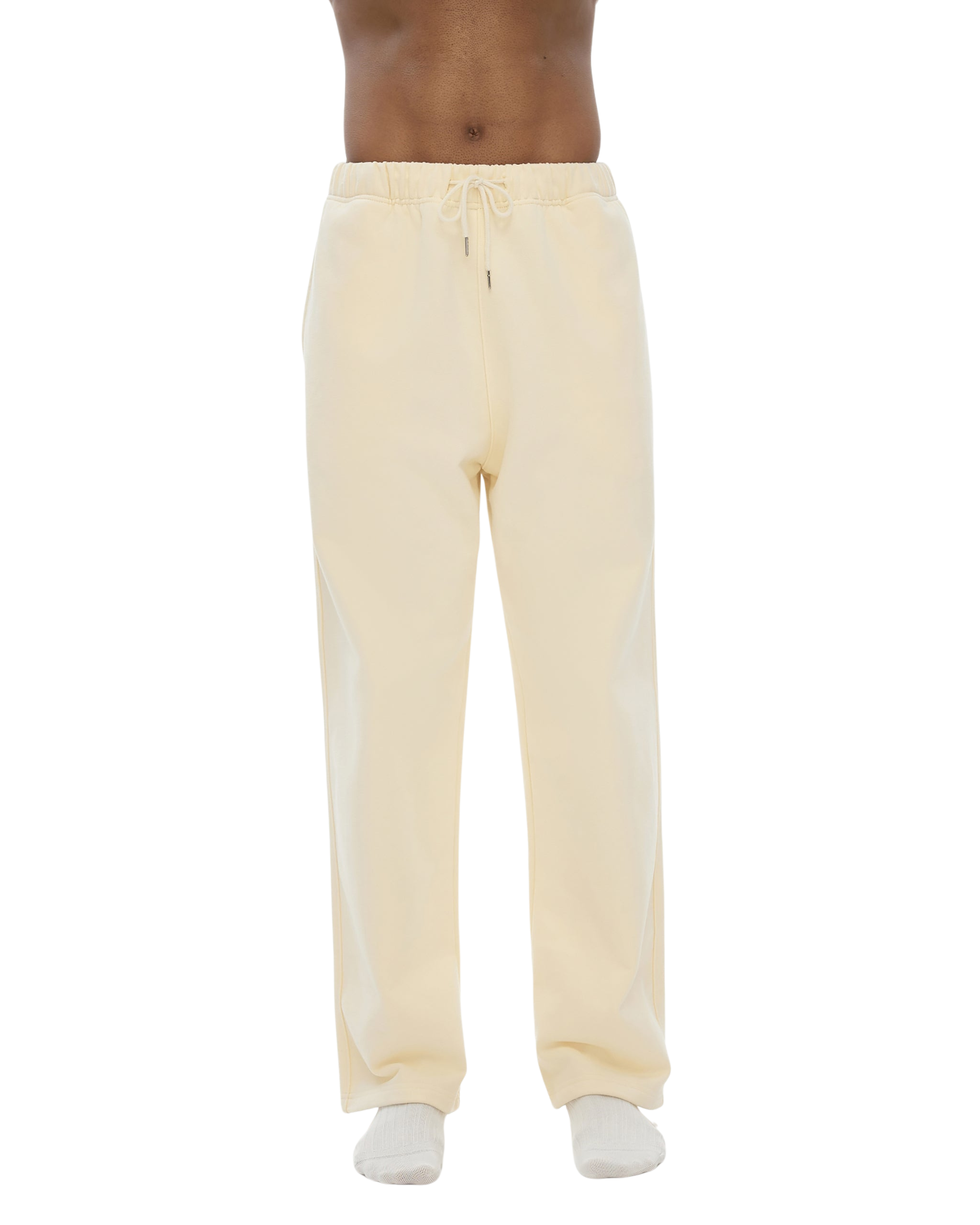 Light yellow sweatpants worn by a person on a white background