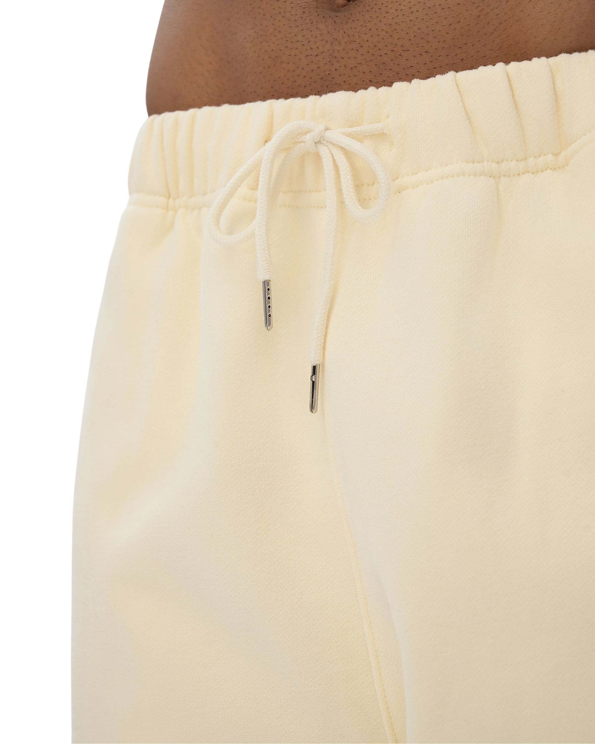 Light yellow sweatpants with drawstring on a white background