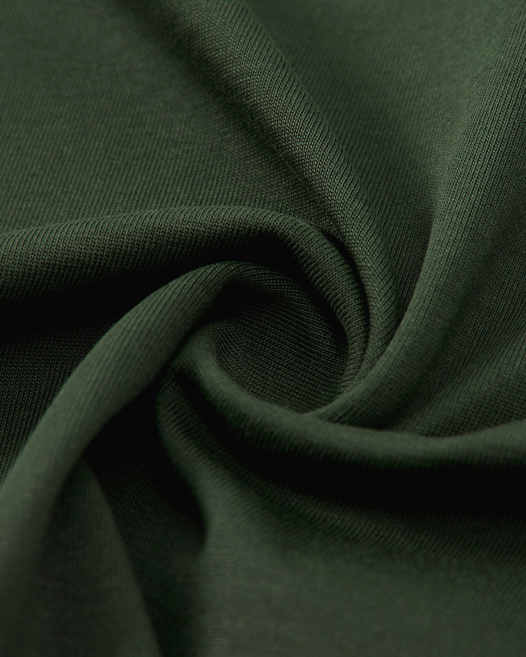 Close-up of dark green fabric with folds