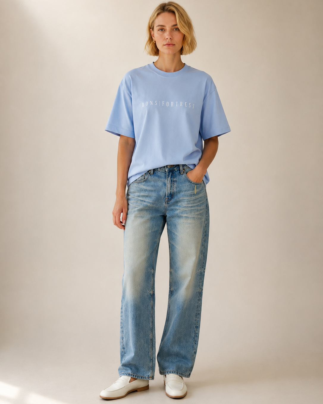 Person wearing a light blue t-shirt and jeans on a plain background