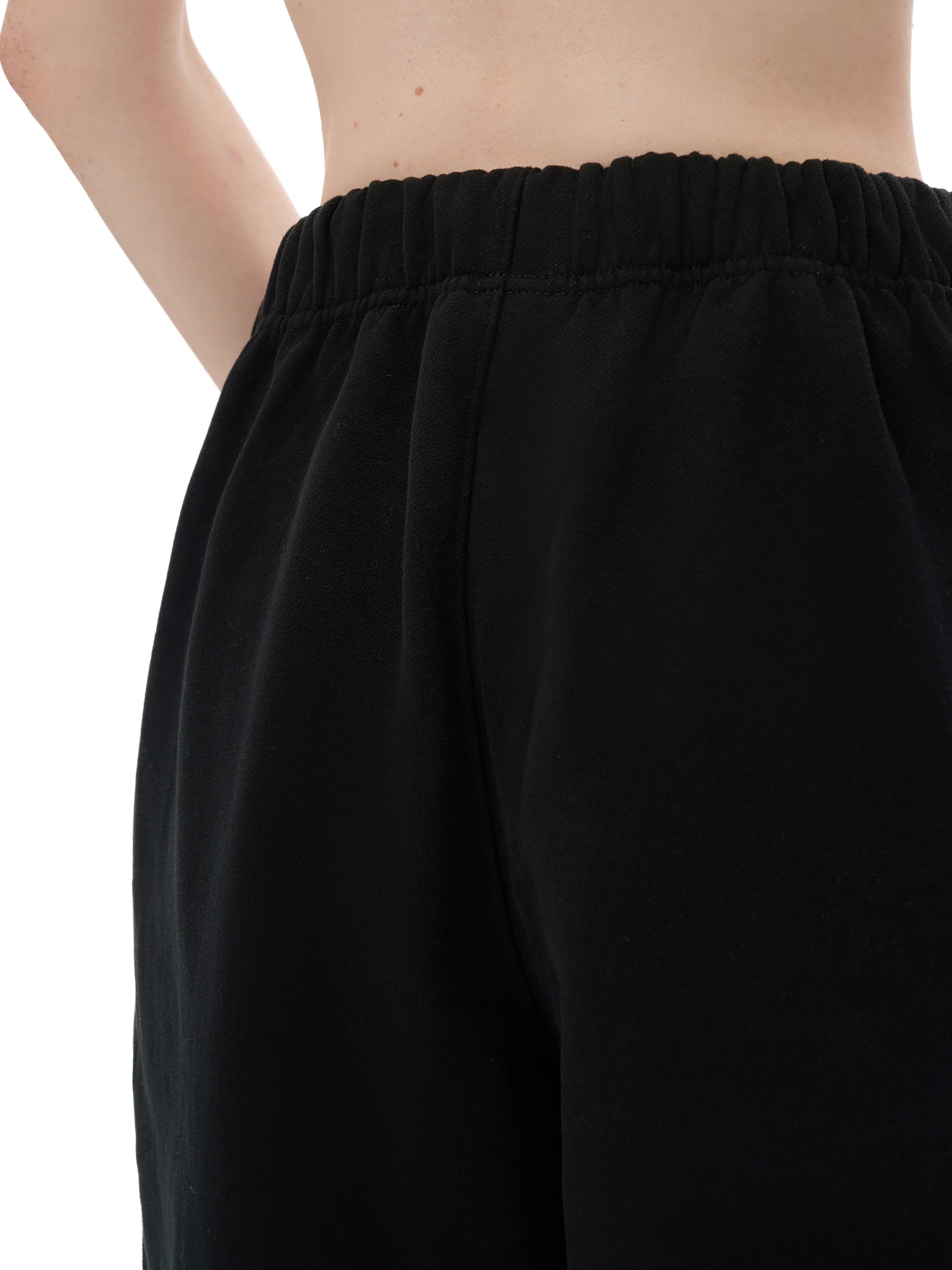 Black pants worn by a person on a white background