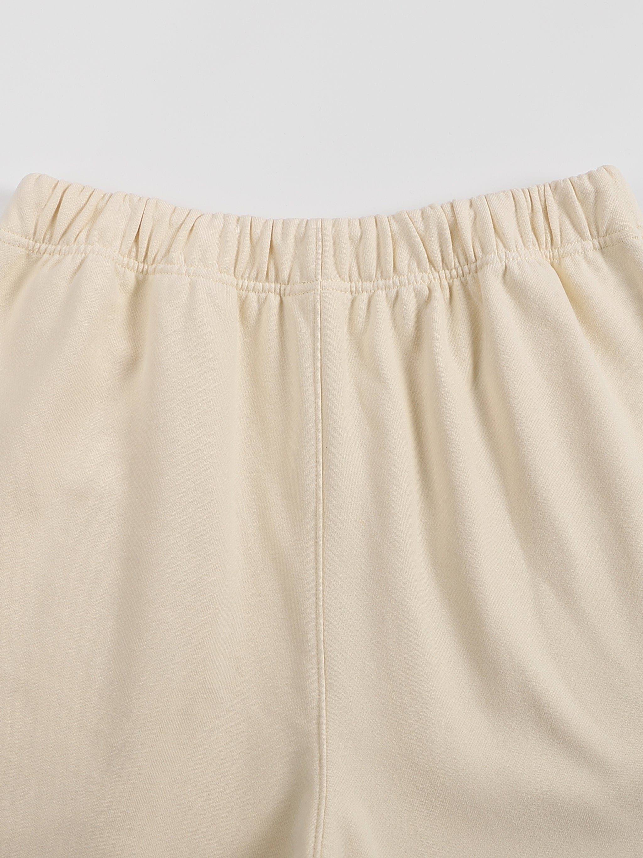 Beige pants with an elastic waistband on a light gray background