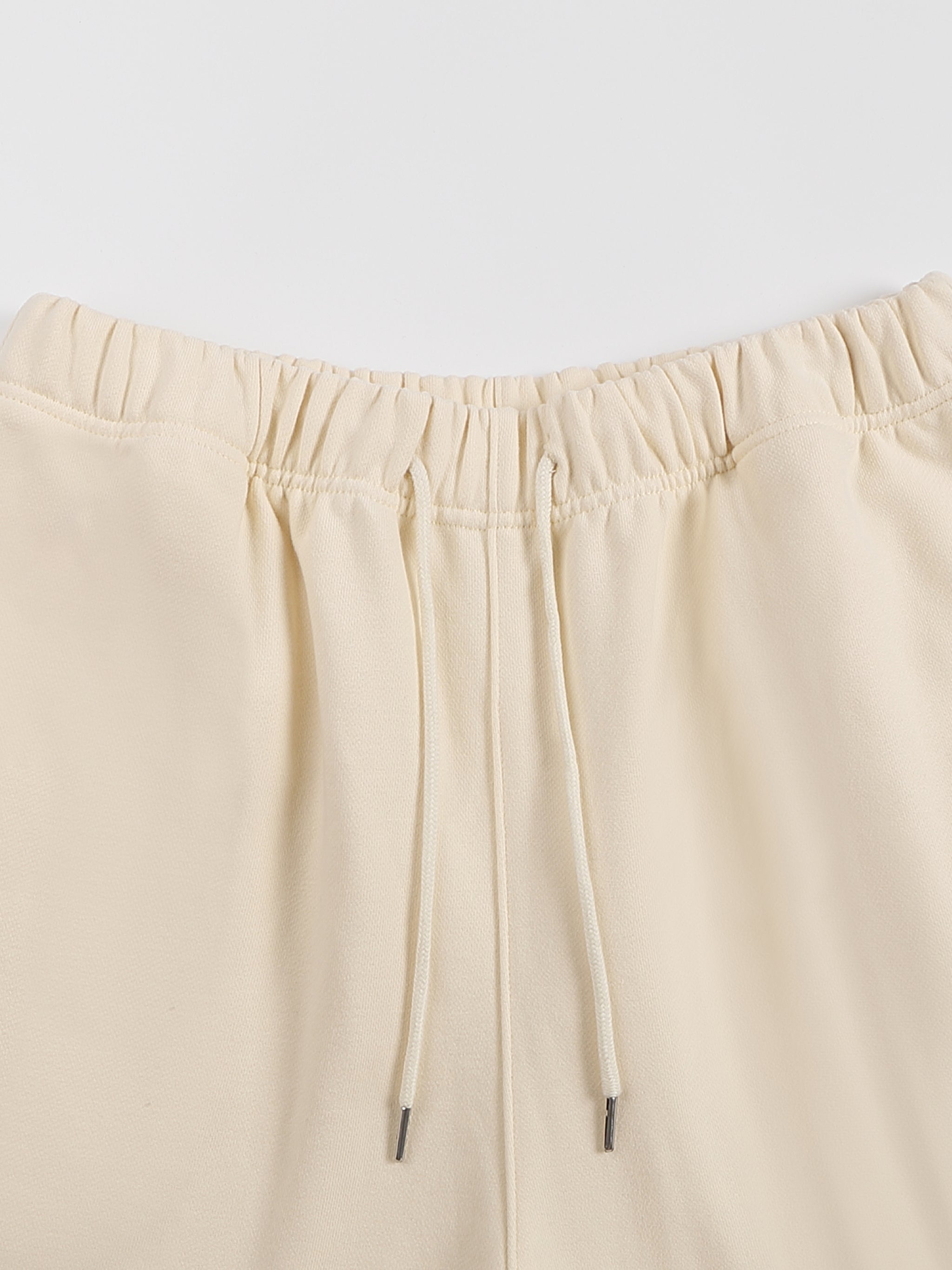 Beige pants with drawstring on a light gray background