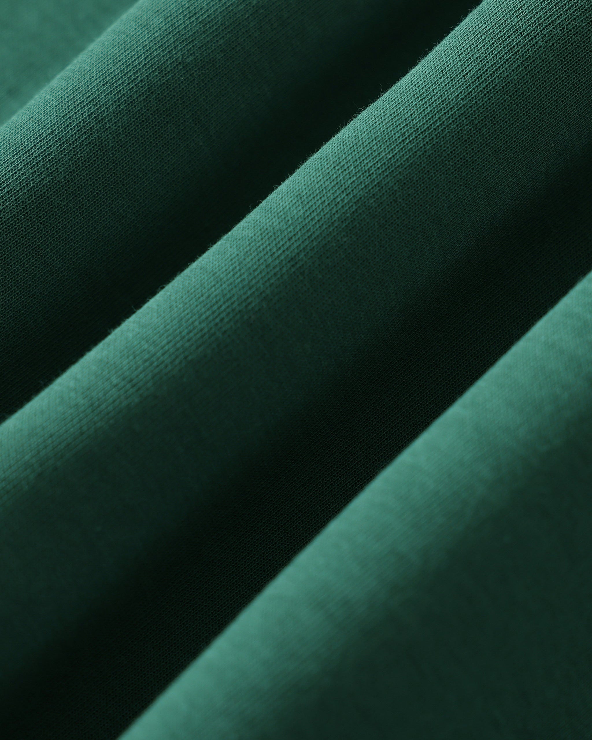 Close-up of dark green fabric with a subtle texture