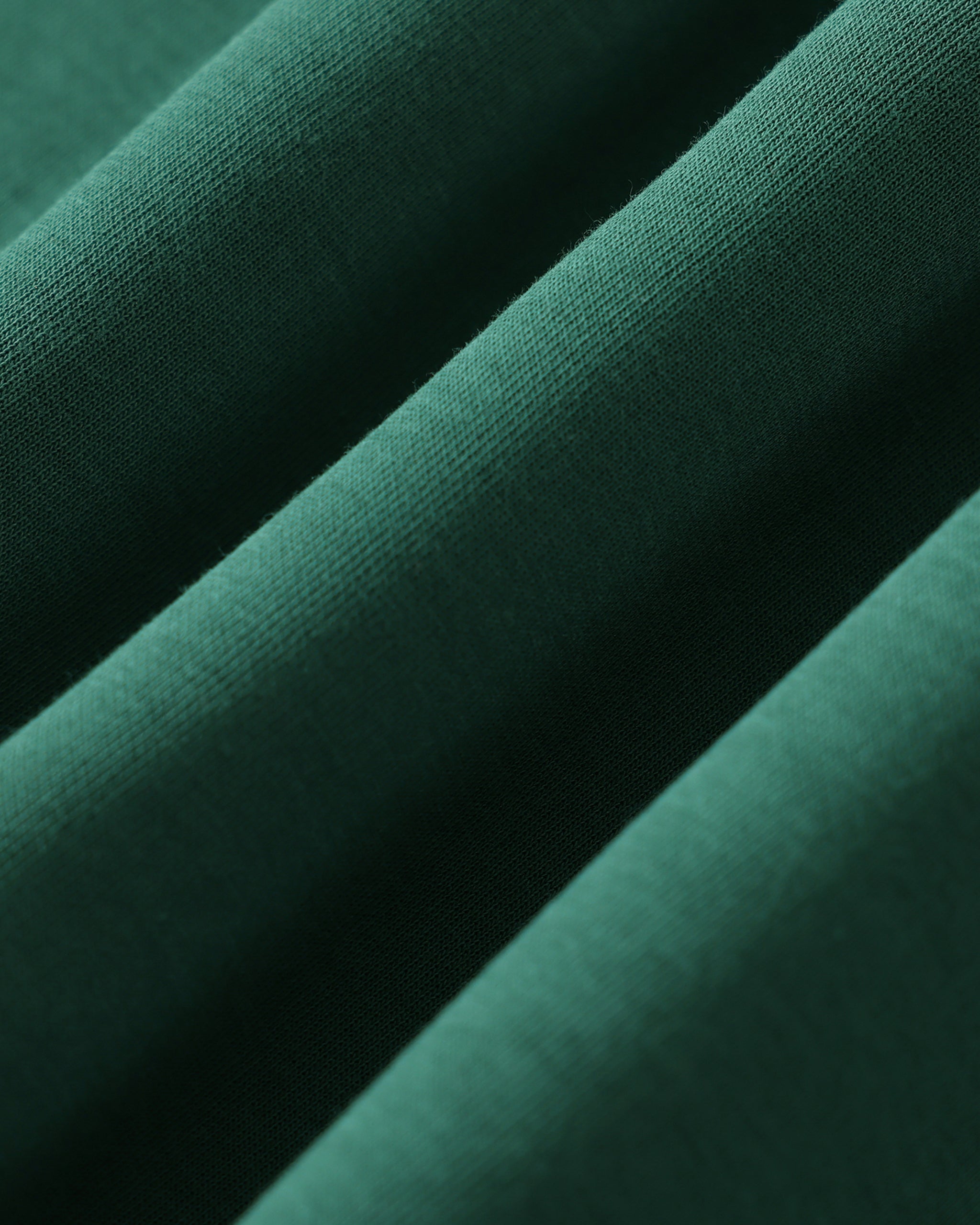 Close-up of dark green fabric with a subtle texture