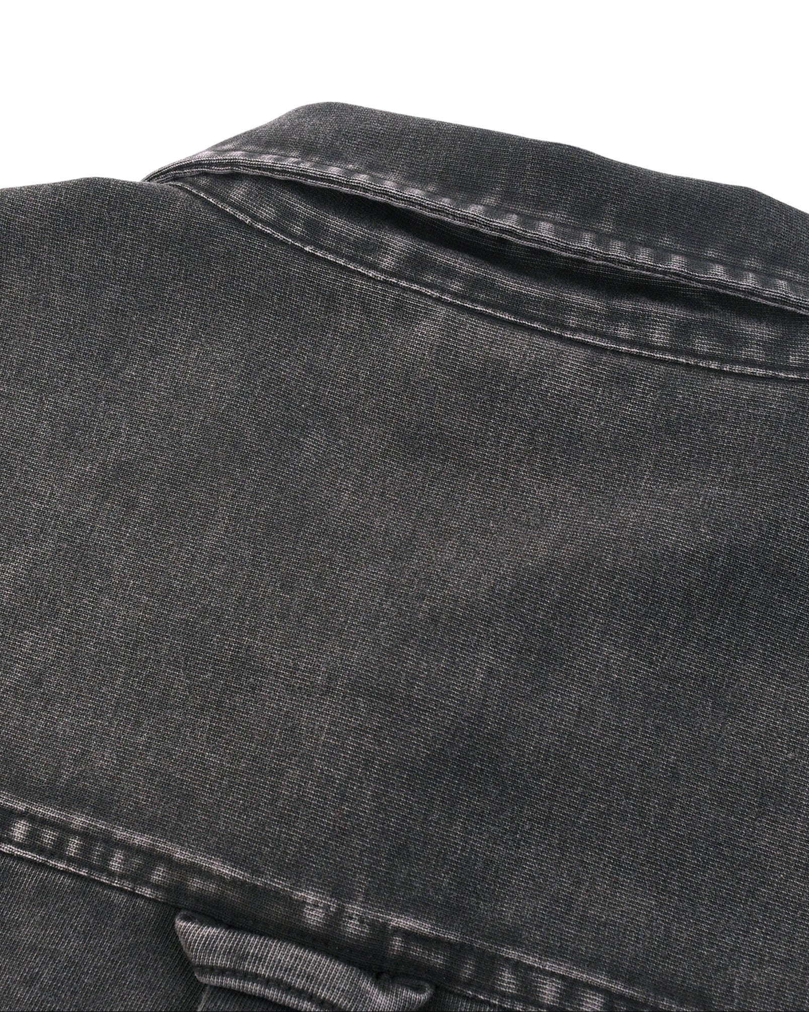 Close-up of a black denim jacket on a white background