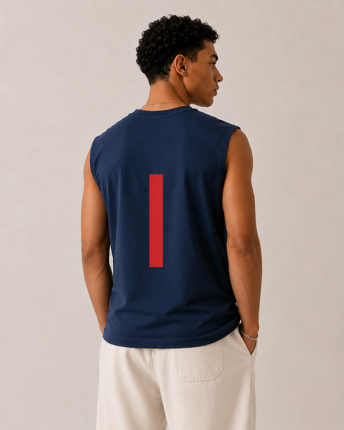 Man wearing a navy sleeveless shirt with a red number on the back against a beige background