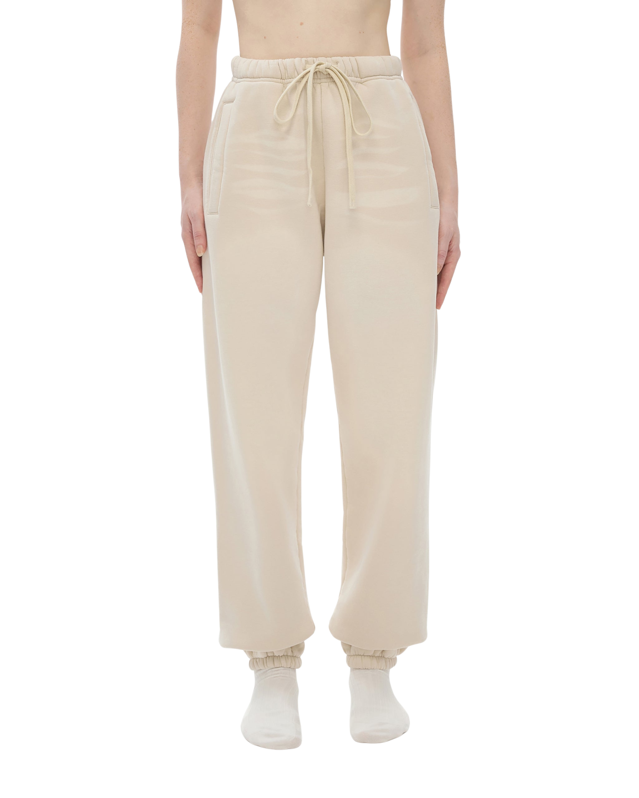 Beige sweatpants worn by a person on a white background