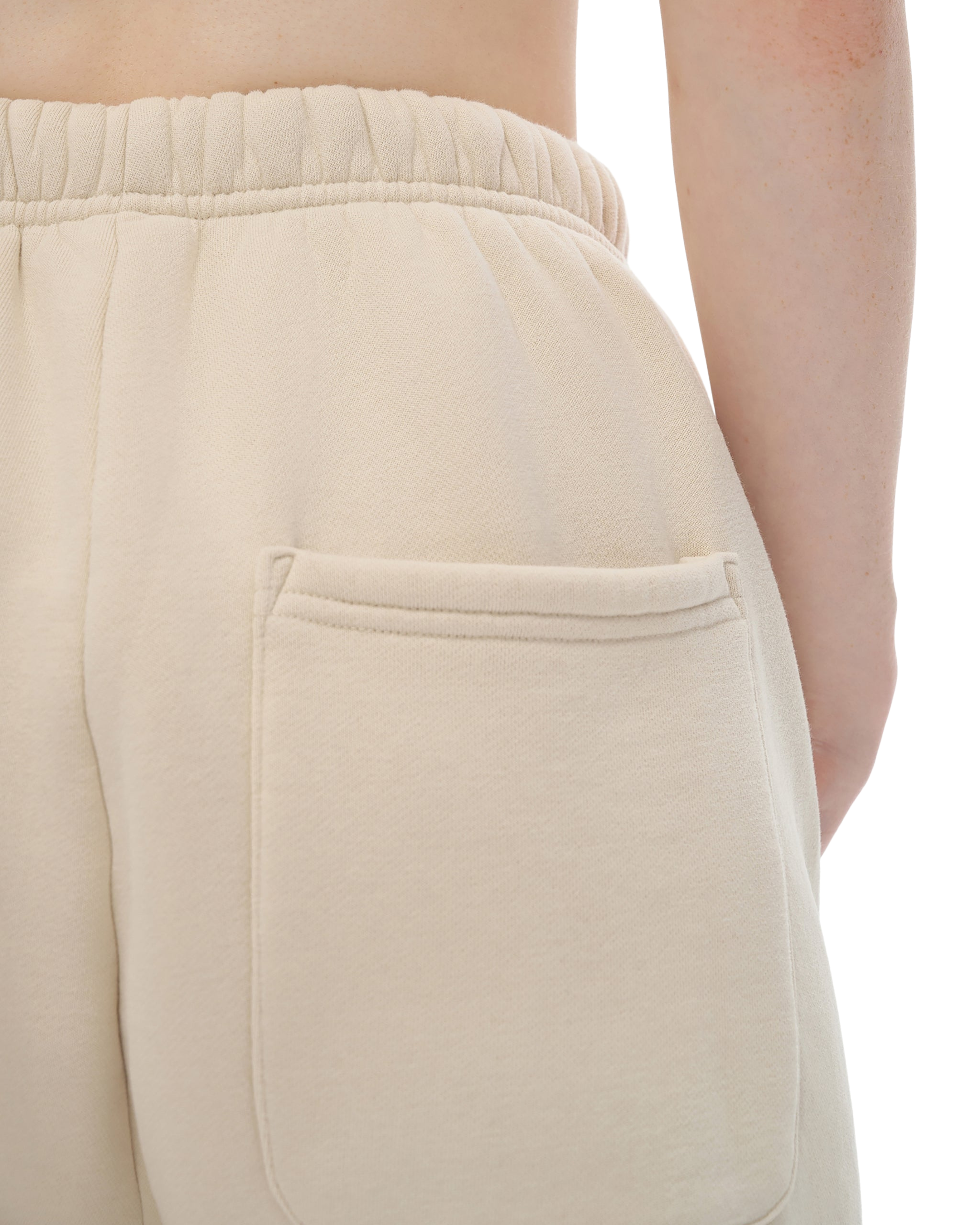 Close-up of beige pants with a pocket on a white background