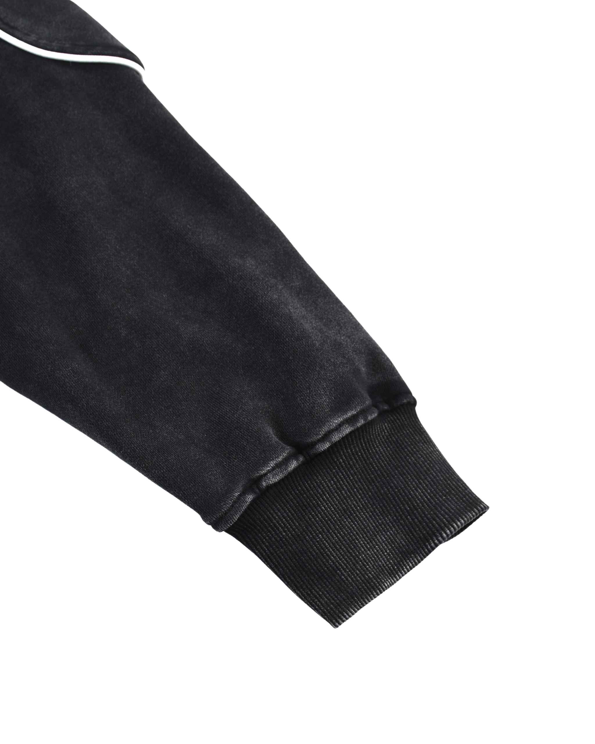 Close-up of a black sweatshirt sleeve with white piping on a white background