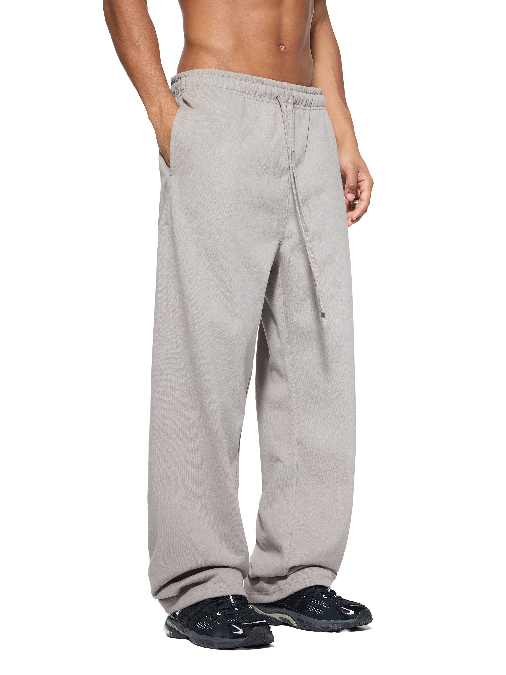 Person wearing light gray sweatpants on a white background