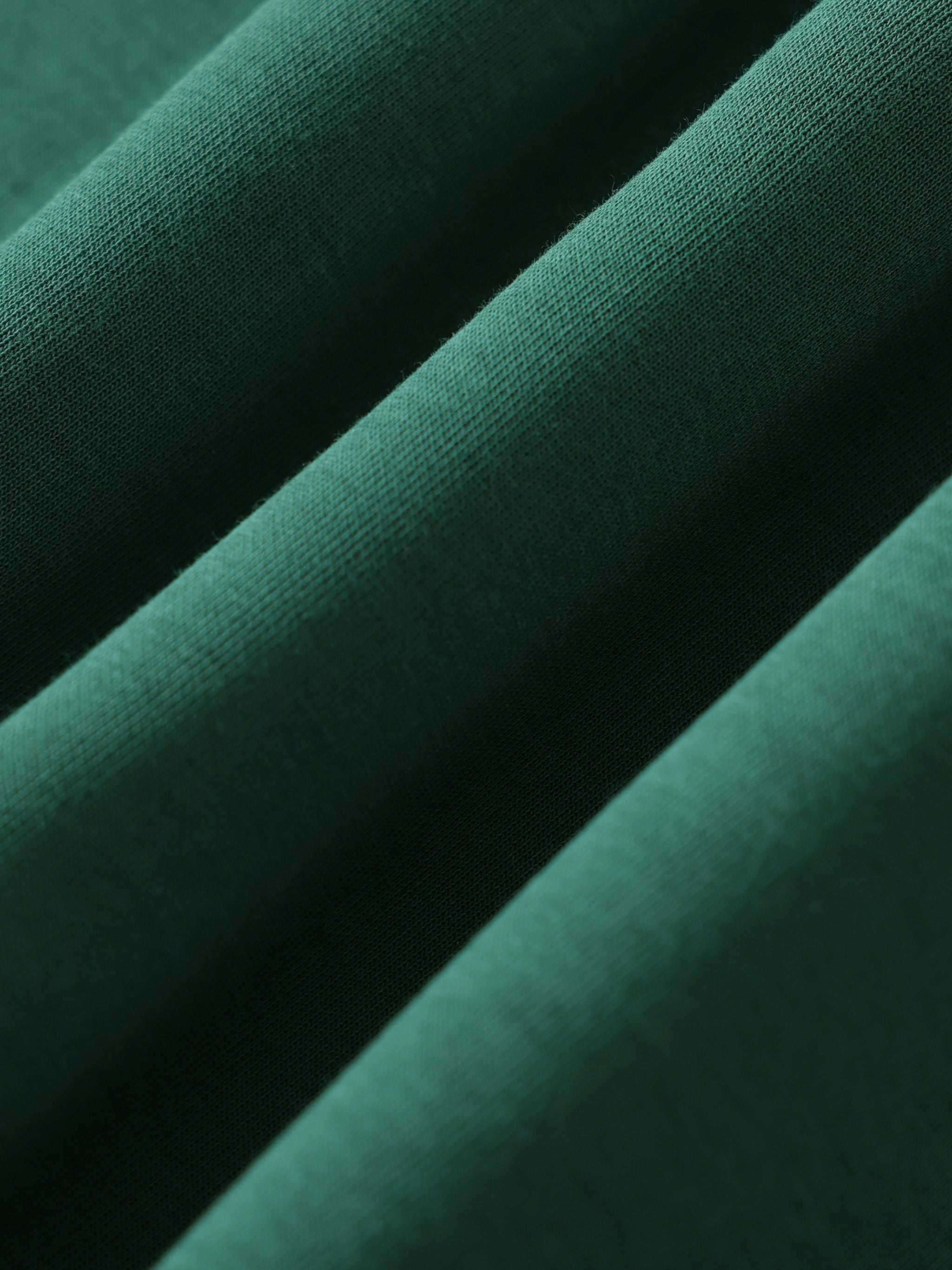 Close-up of dark green fabric with a subtle texture