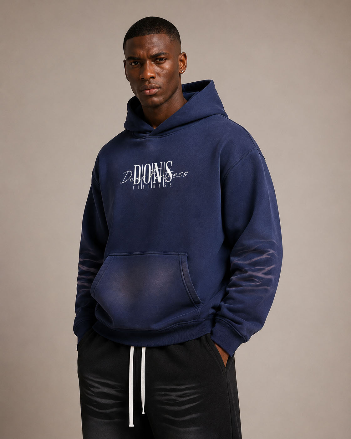 Man wearing a navy blue hoodie with branding on a beige background