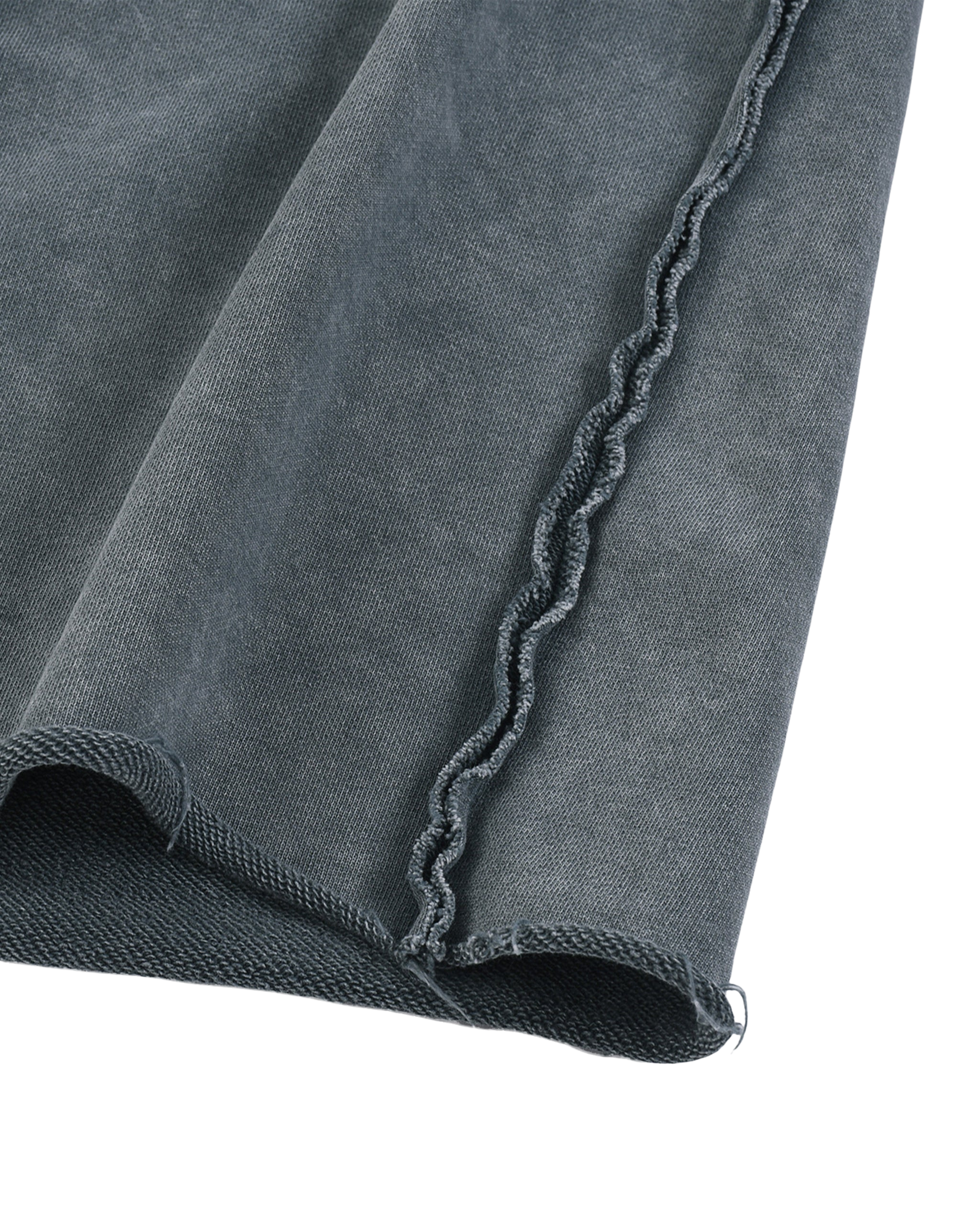 Close-up of a dark gray fabric with frayed edge on a white background