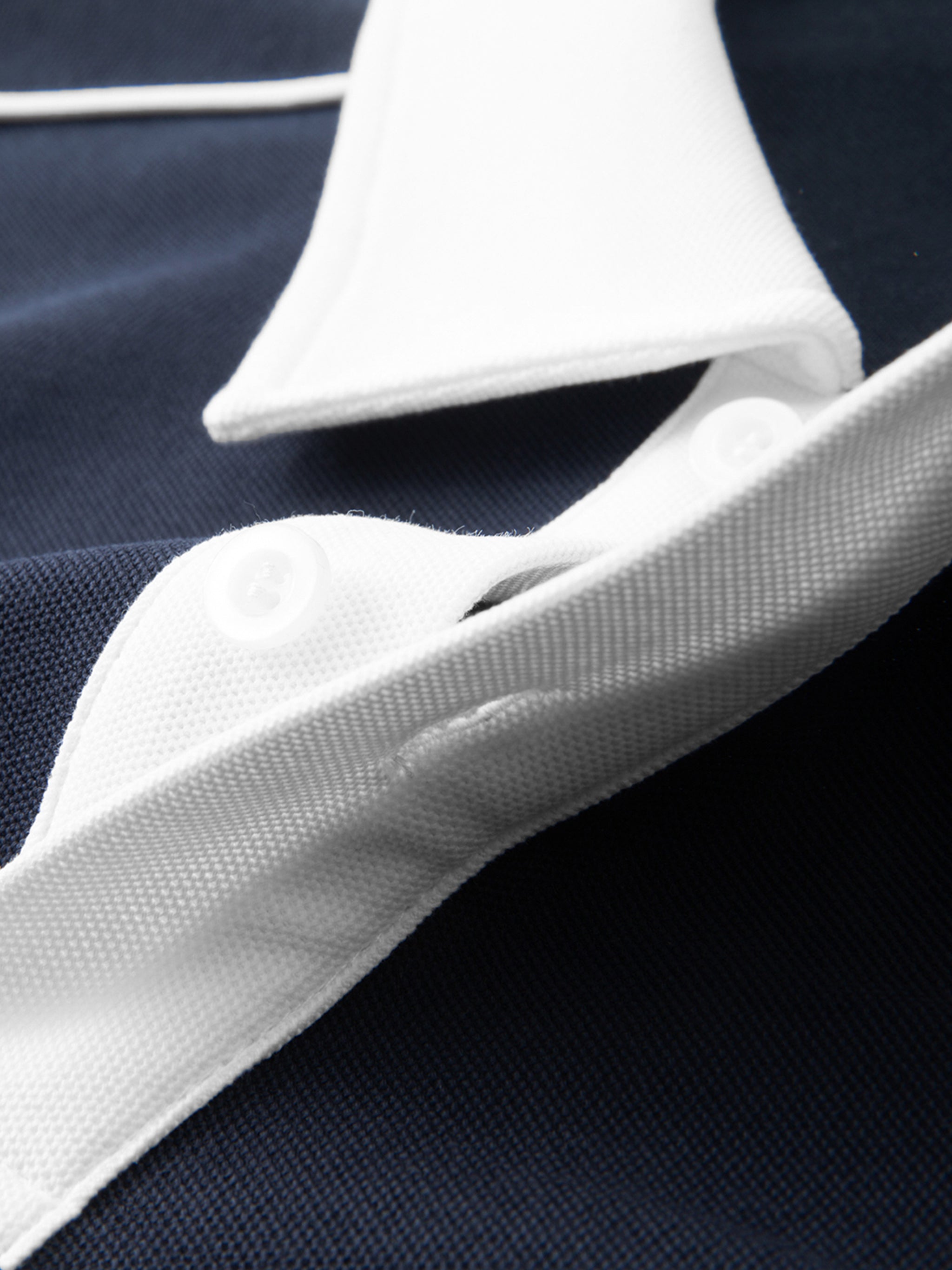 Close-up of a navy blue shirt with white collar and buttons.